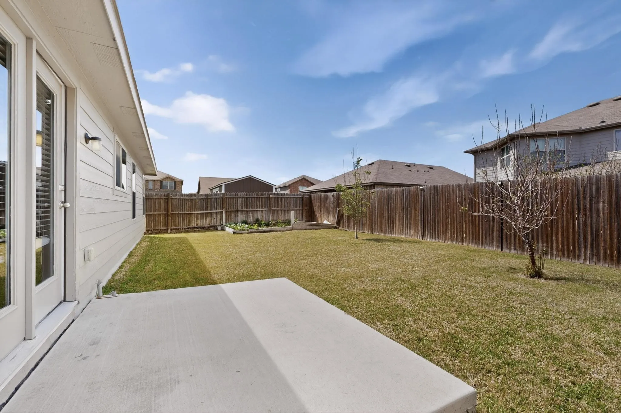 Fenced backyard featuring a patio