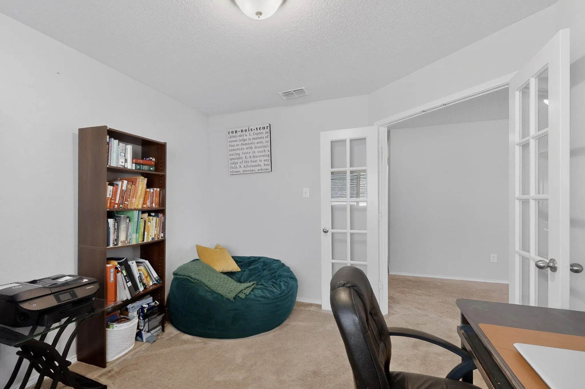 Office space featuring light carpet, french doors, and a textured ceiling
