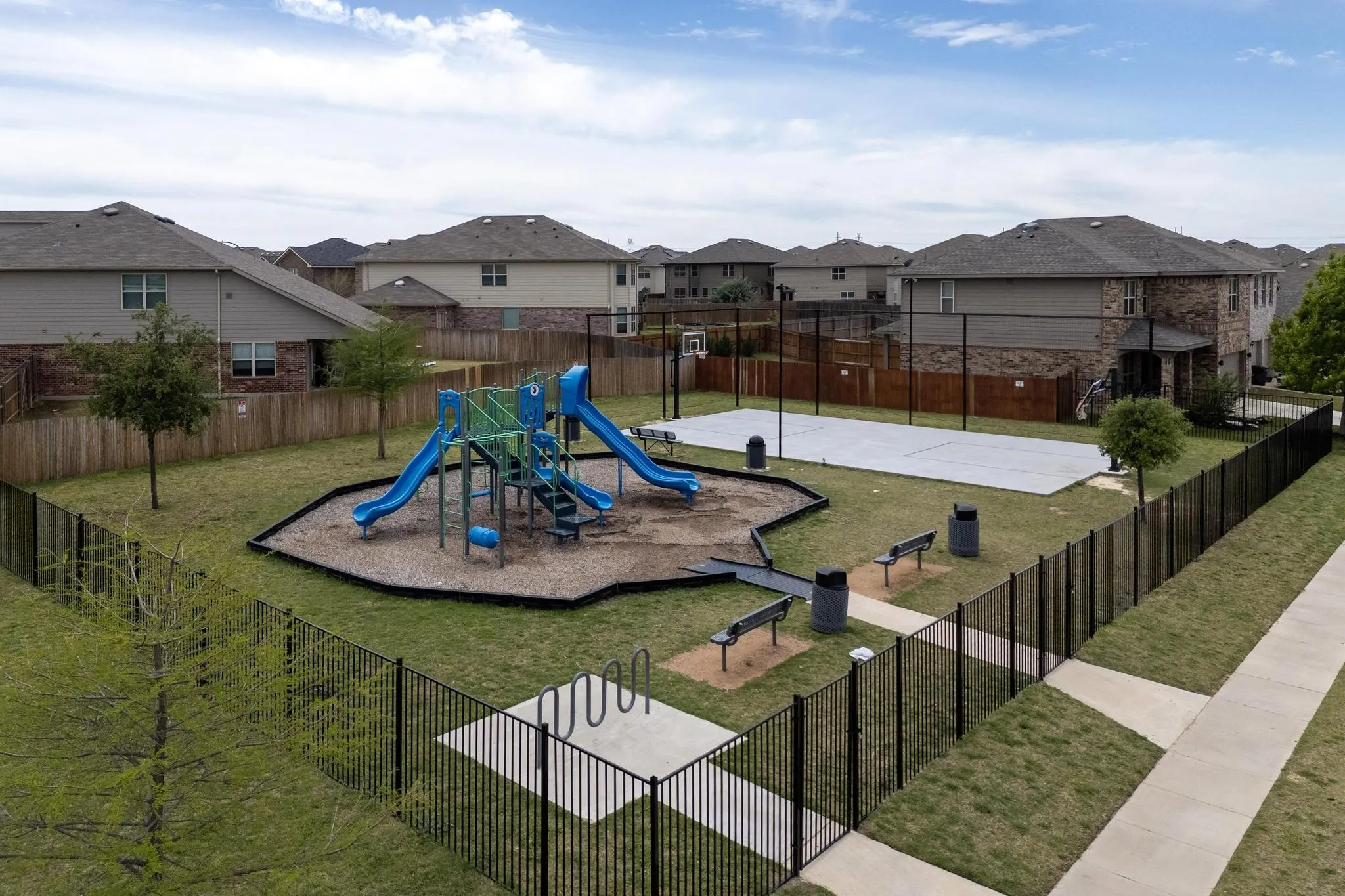 Community playground with a residential view and community basketball court