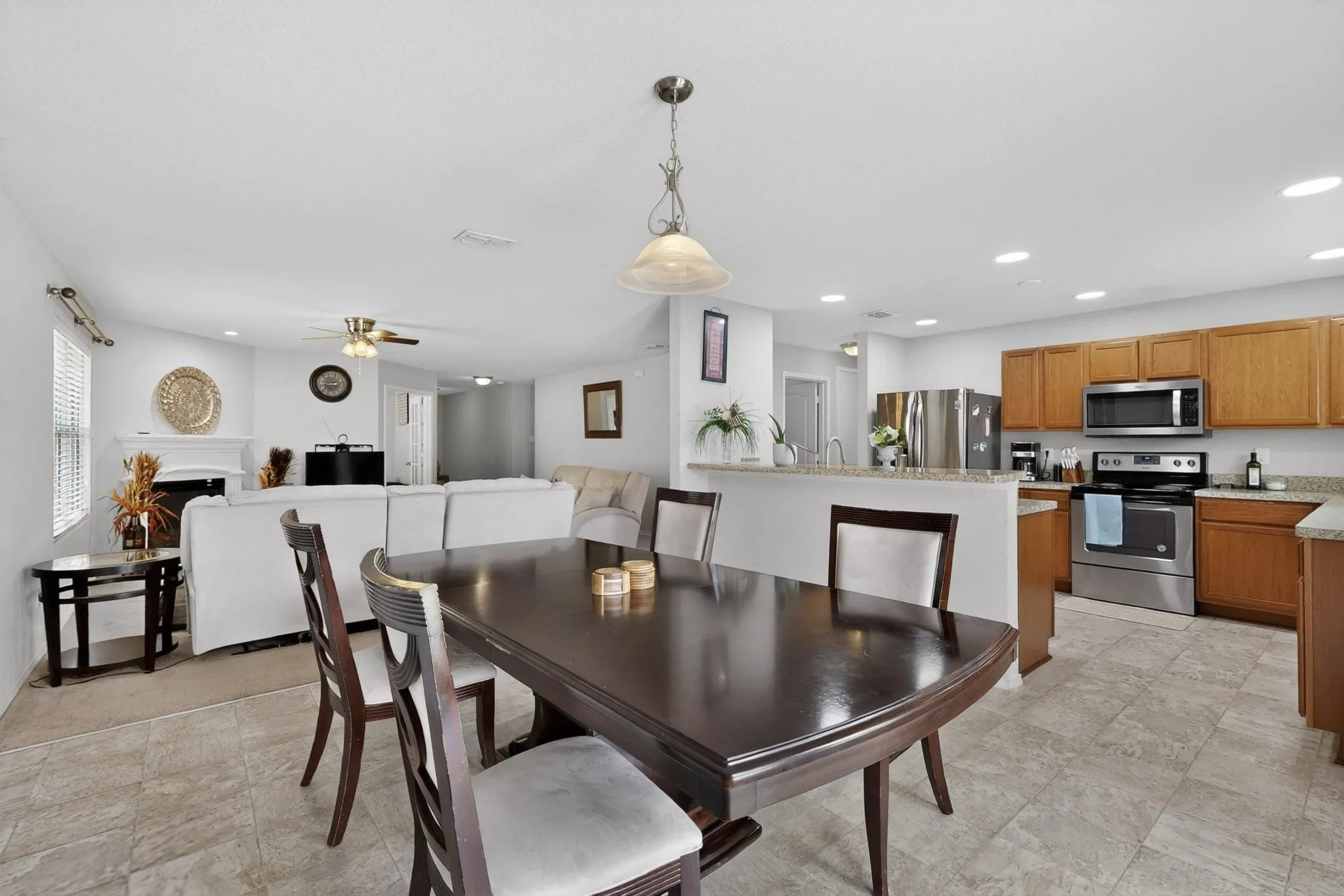 Dining area featuring a fireplace, a ceiling fan, and recessed lighting