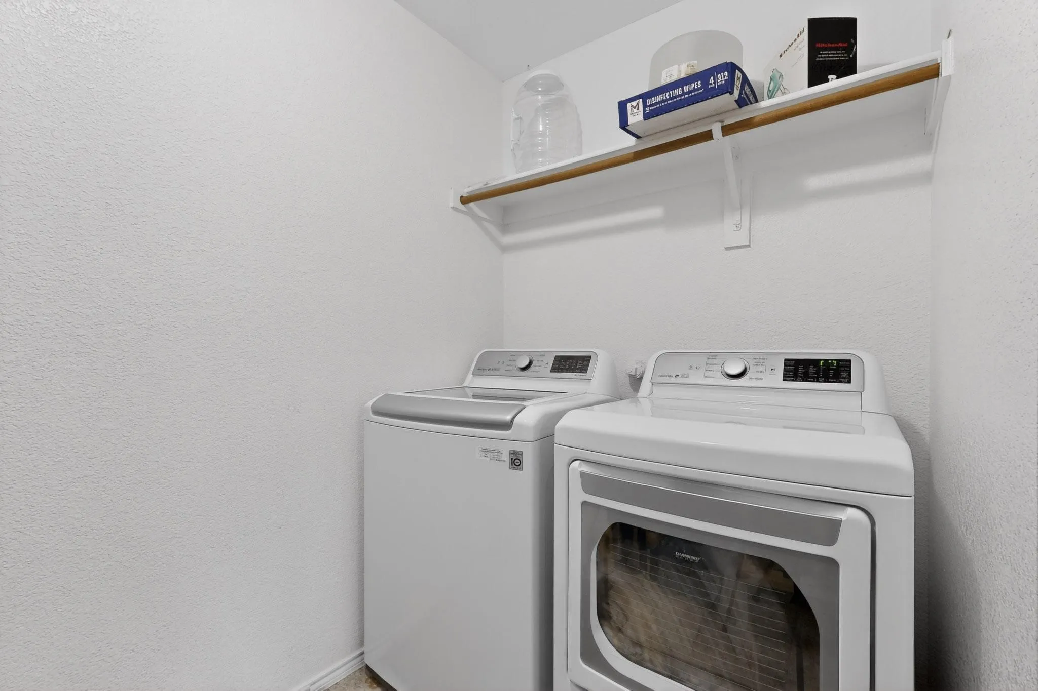 Laundry room featuring washer and dryer and a textured wall