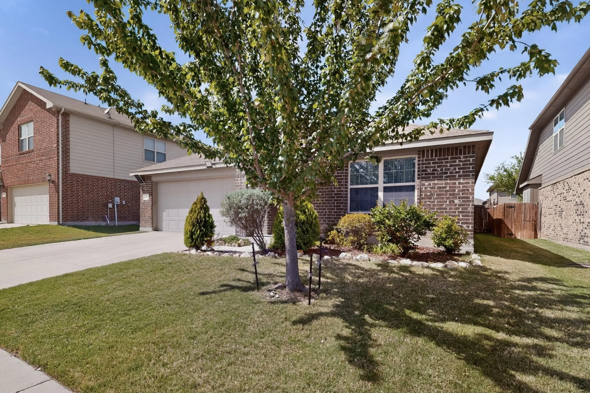View of front of home with brick siding, concrete driveway, and a garage