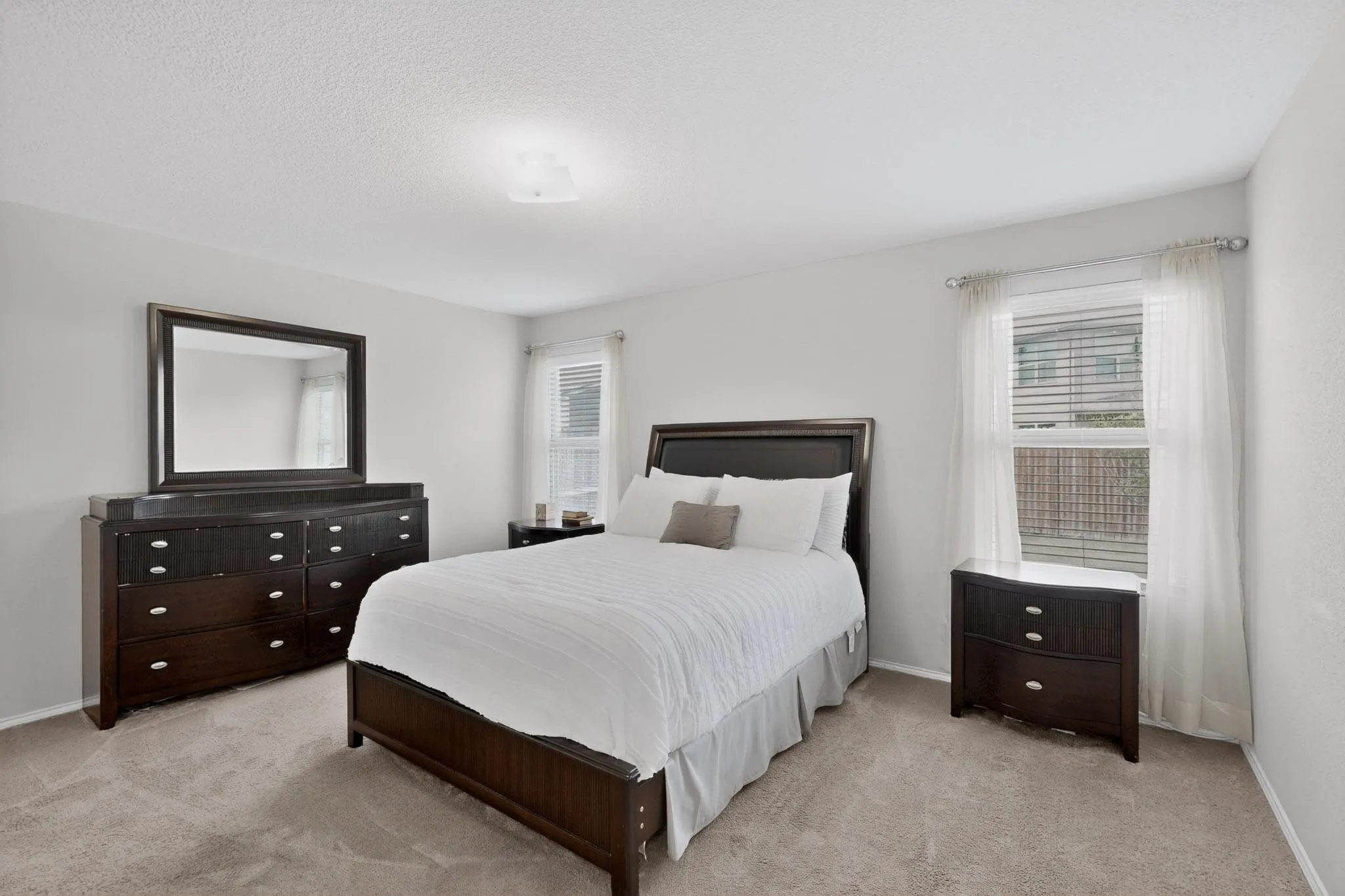 Bedroom with light colored carpet and baseboards