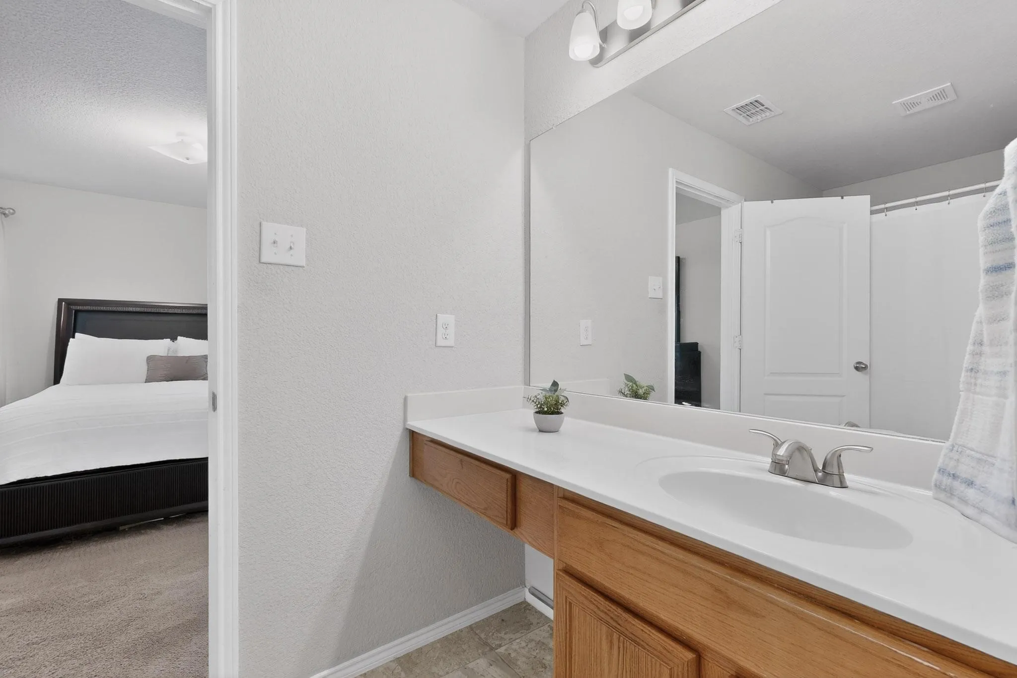 Ensuite bathroom featuring vanity, a shower with shower curtain, and a textured wall