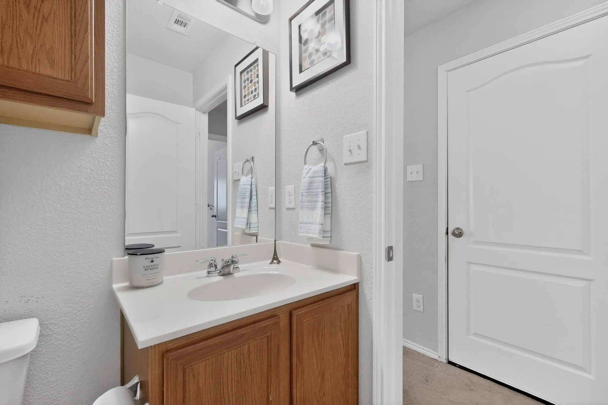 Half bath featuring vanity and a textured wall