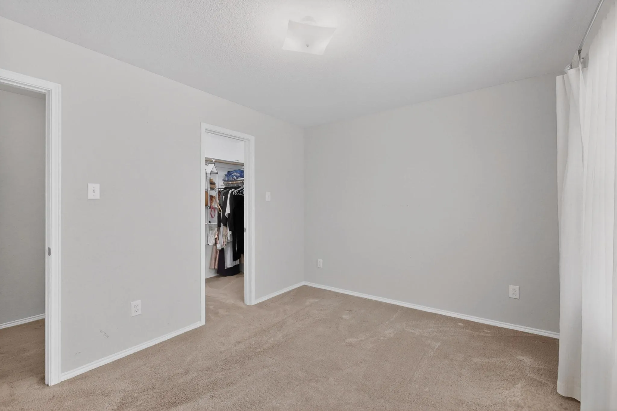 Unfurnished bedroom featuring a spacious closet and light carpet