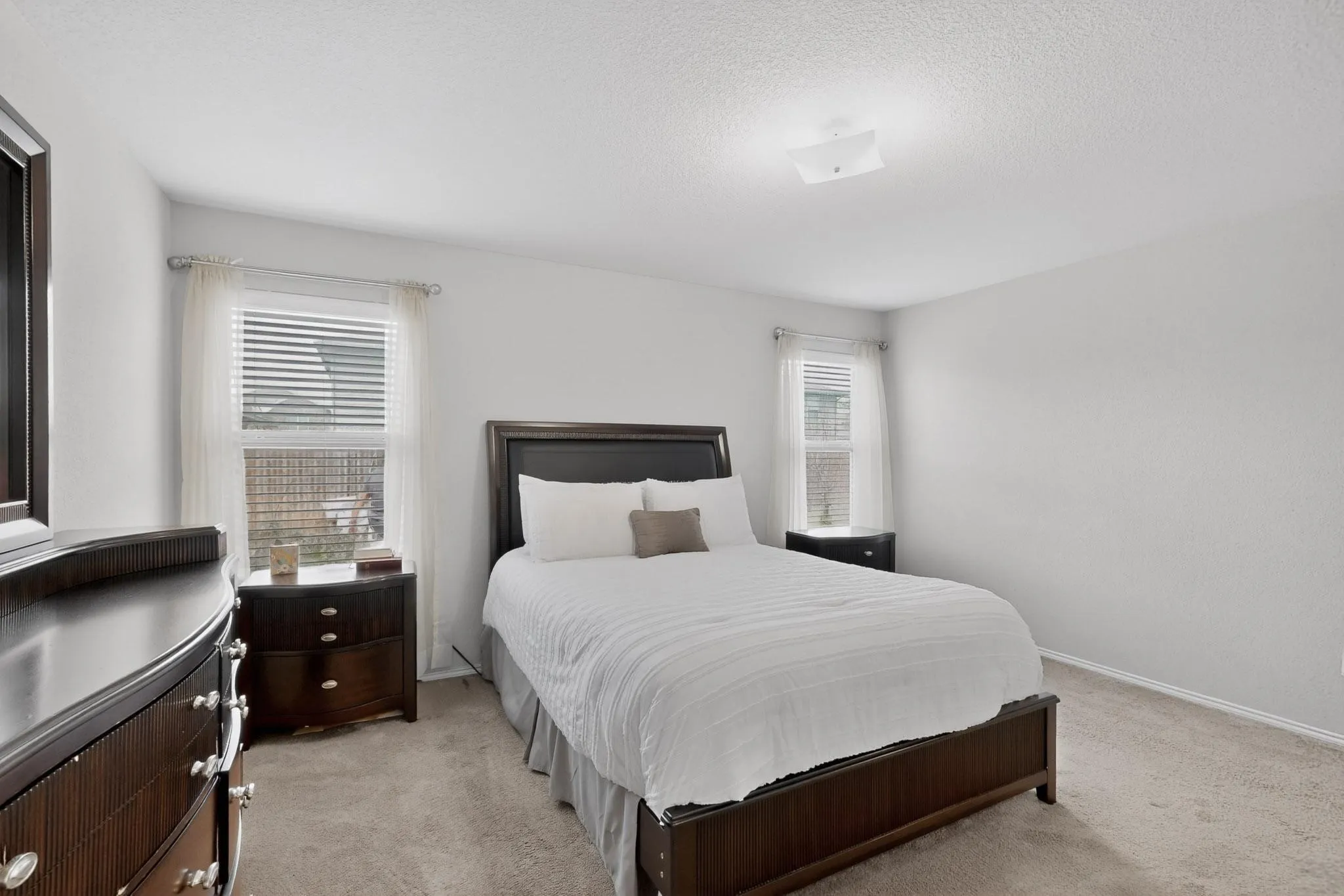 Bedroom with light carpet and a textured ceiling