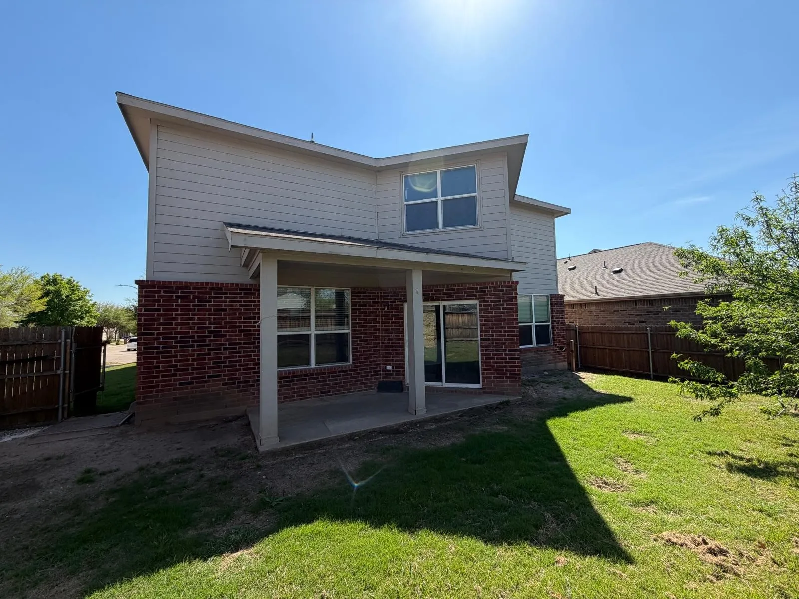 Rear view of property with a patio, brick siding, and a fenced backyard
