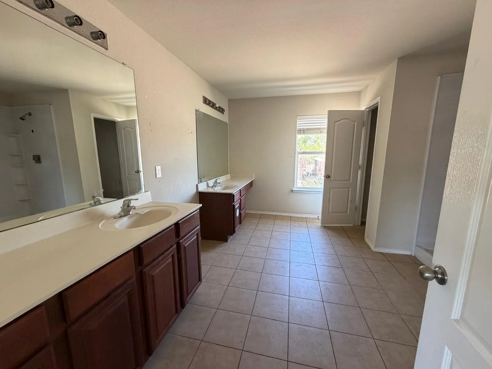 Bathroom with two vanities and light tile patterned floors