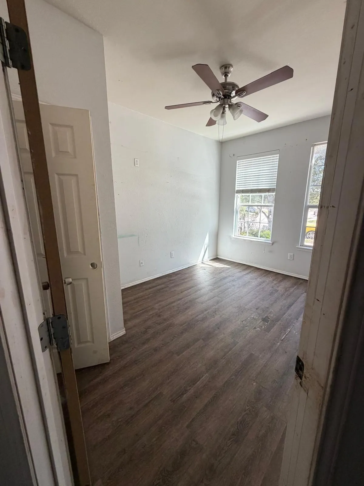 Unfurnished room featuring dark wood finished floors and a ceiling fan