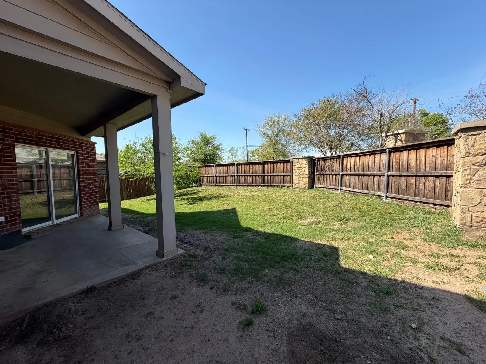 Fenced backyard with a patio area