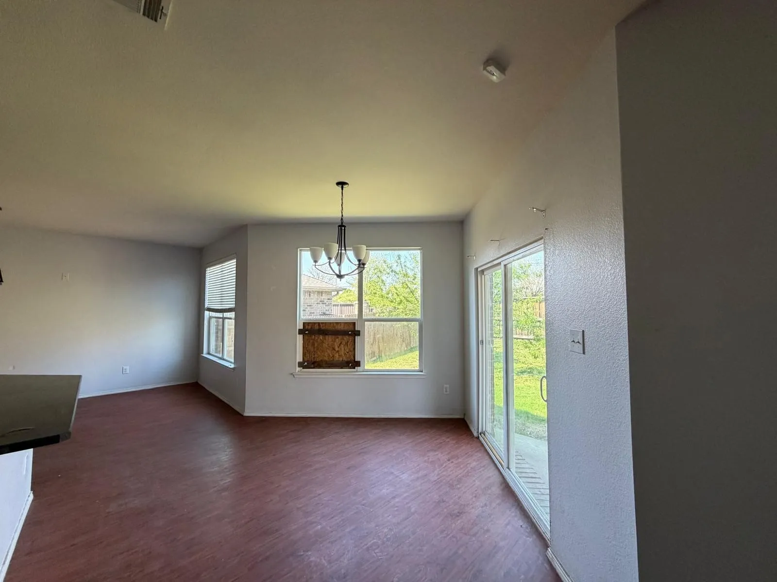 Unfurnished dining area with dark wood finished floors, healthy amount of natural light, and suspended lighting