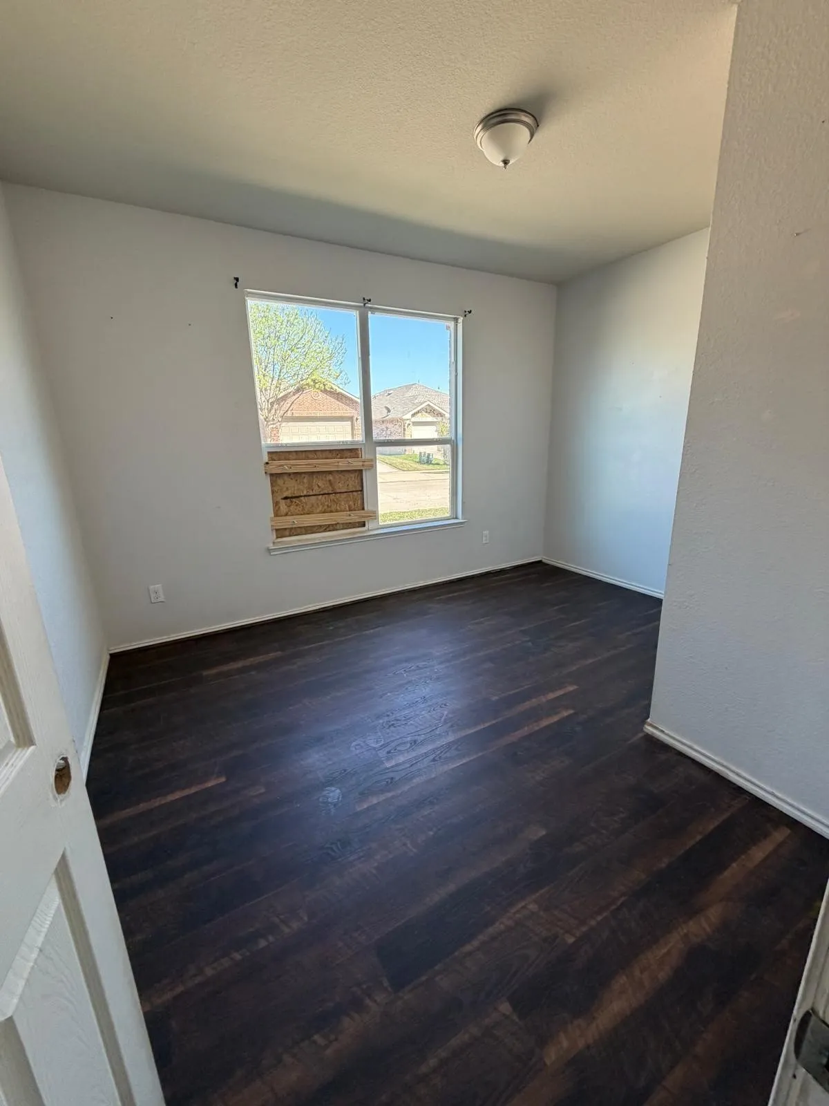 Spare room with dark wood-style flooring and a textured ceiling