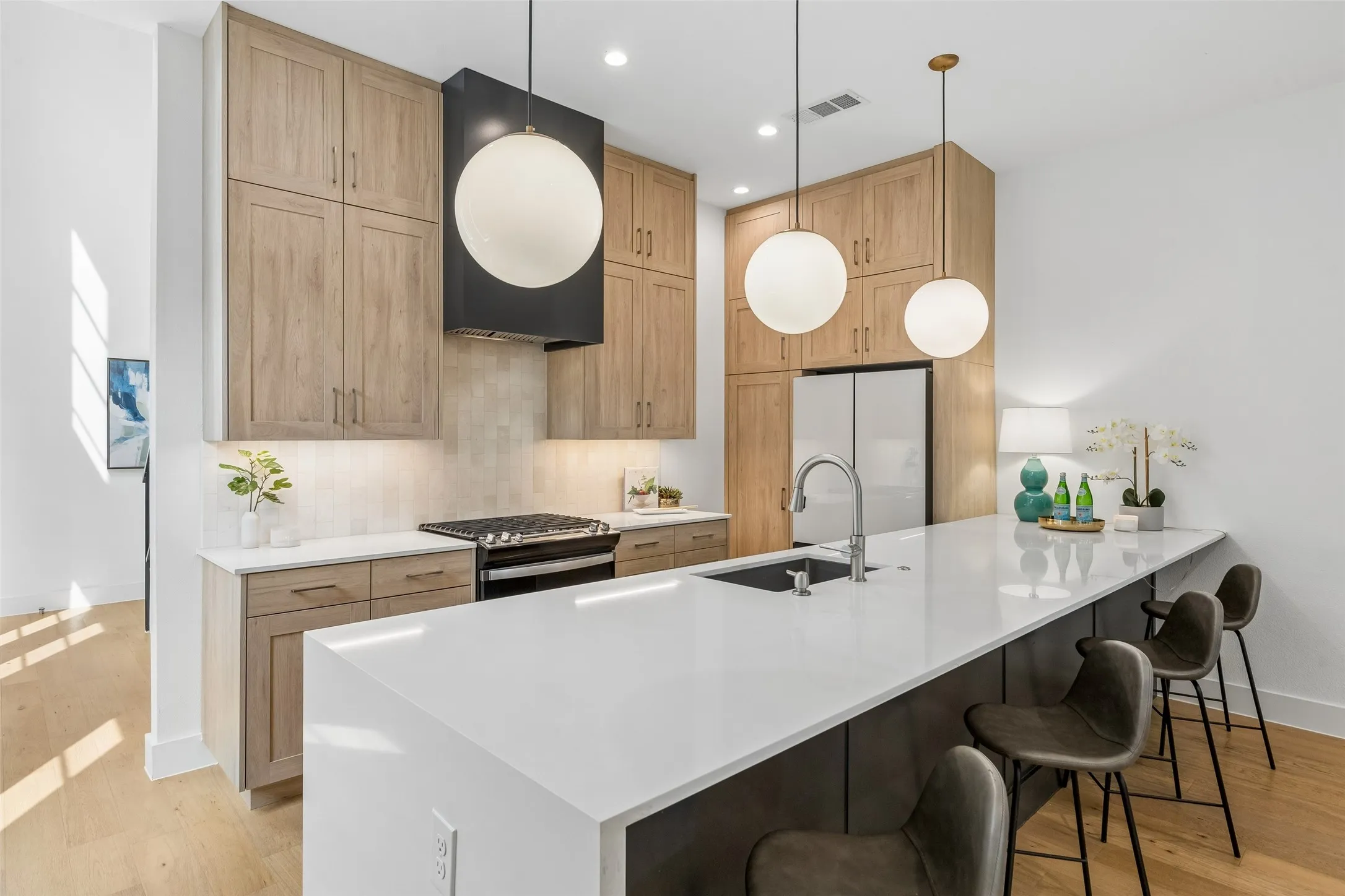 Kitchen featuring a breakfast bar, light wood-type flooring, and light stone counters