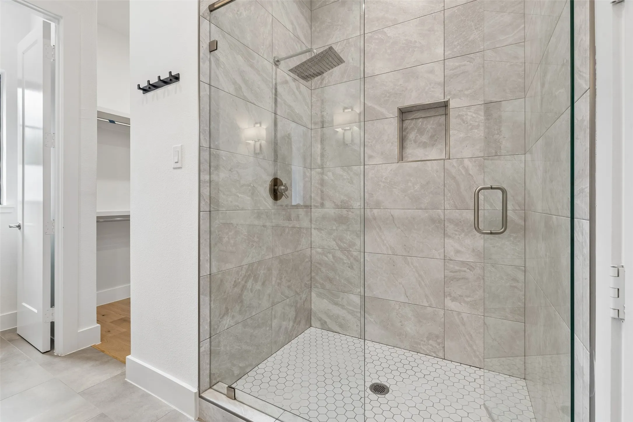 Bathroom featuring a walk in closet, a stall shower, and light tile patterned floors
