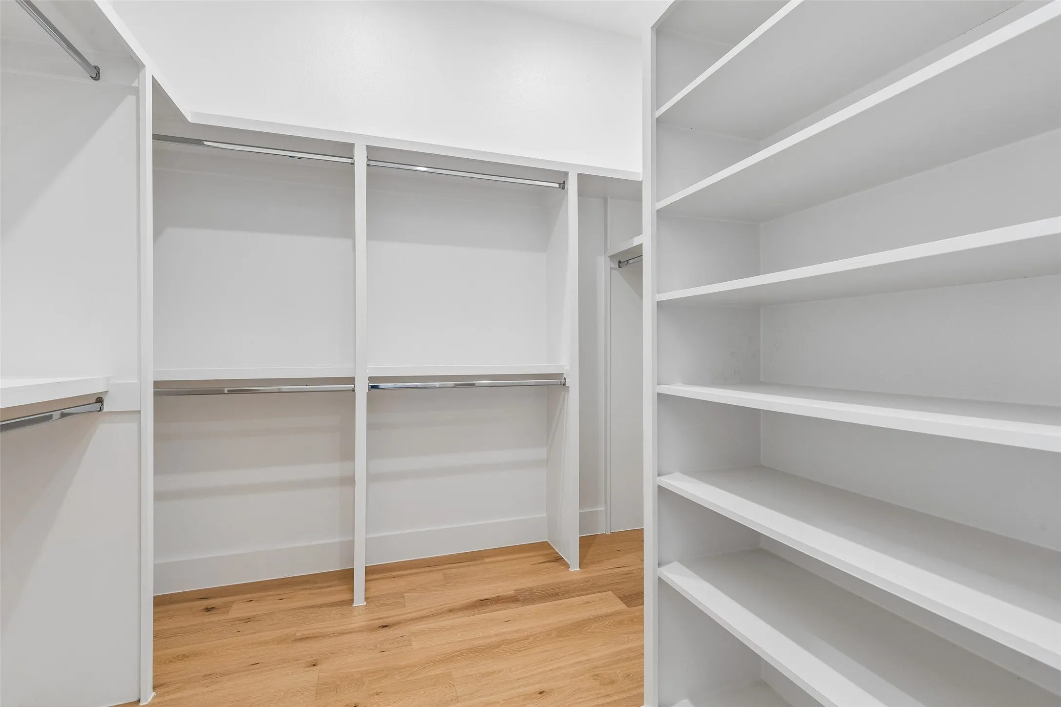 Walk in closet with light wood-type flooring