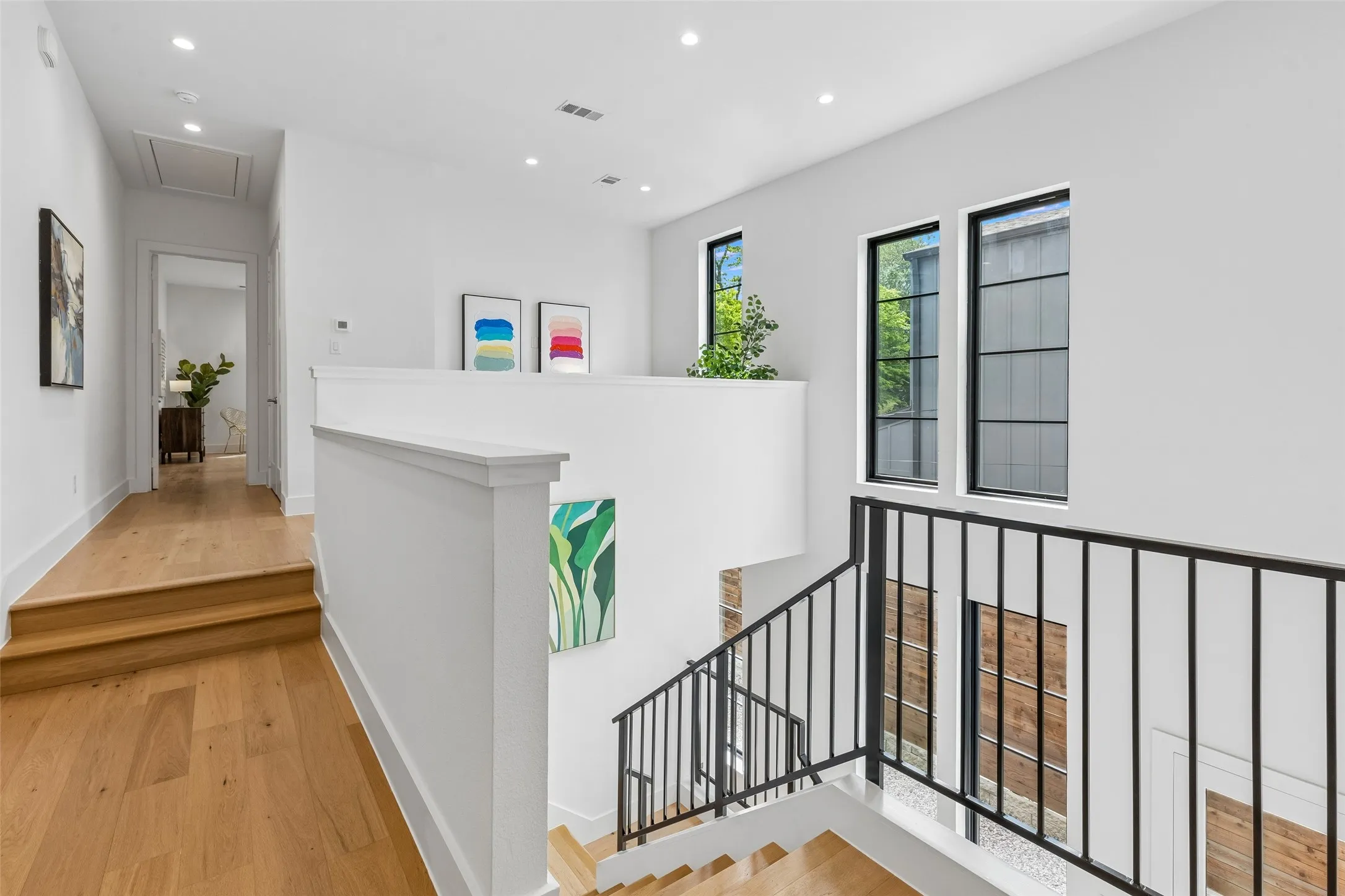 Hallway with light wood-type flooring and recessed lighting