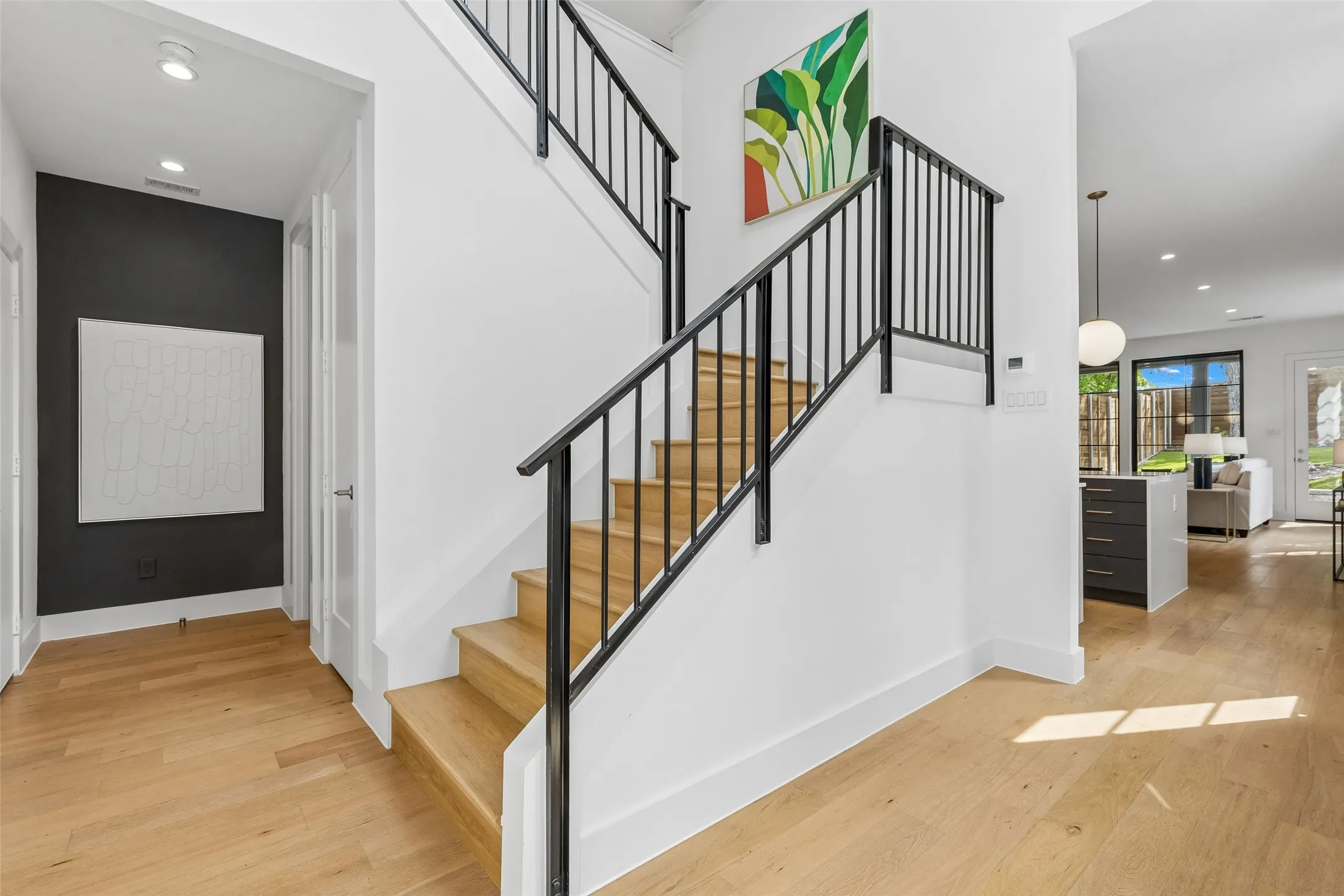 Stairs with recessed lighting and hardwood / wood-style floors