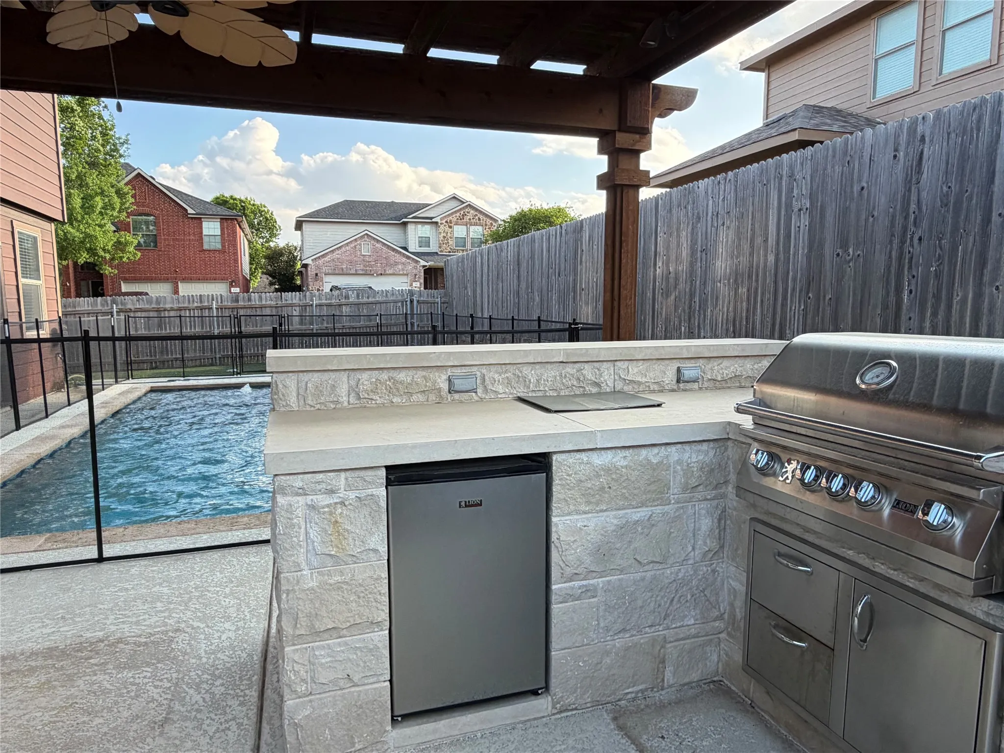 Fenced backyard with area for grilling, a patio area, and ceiling fan