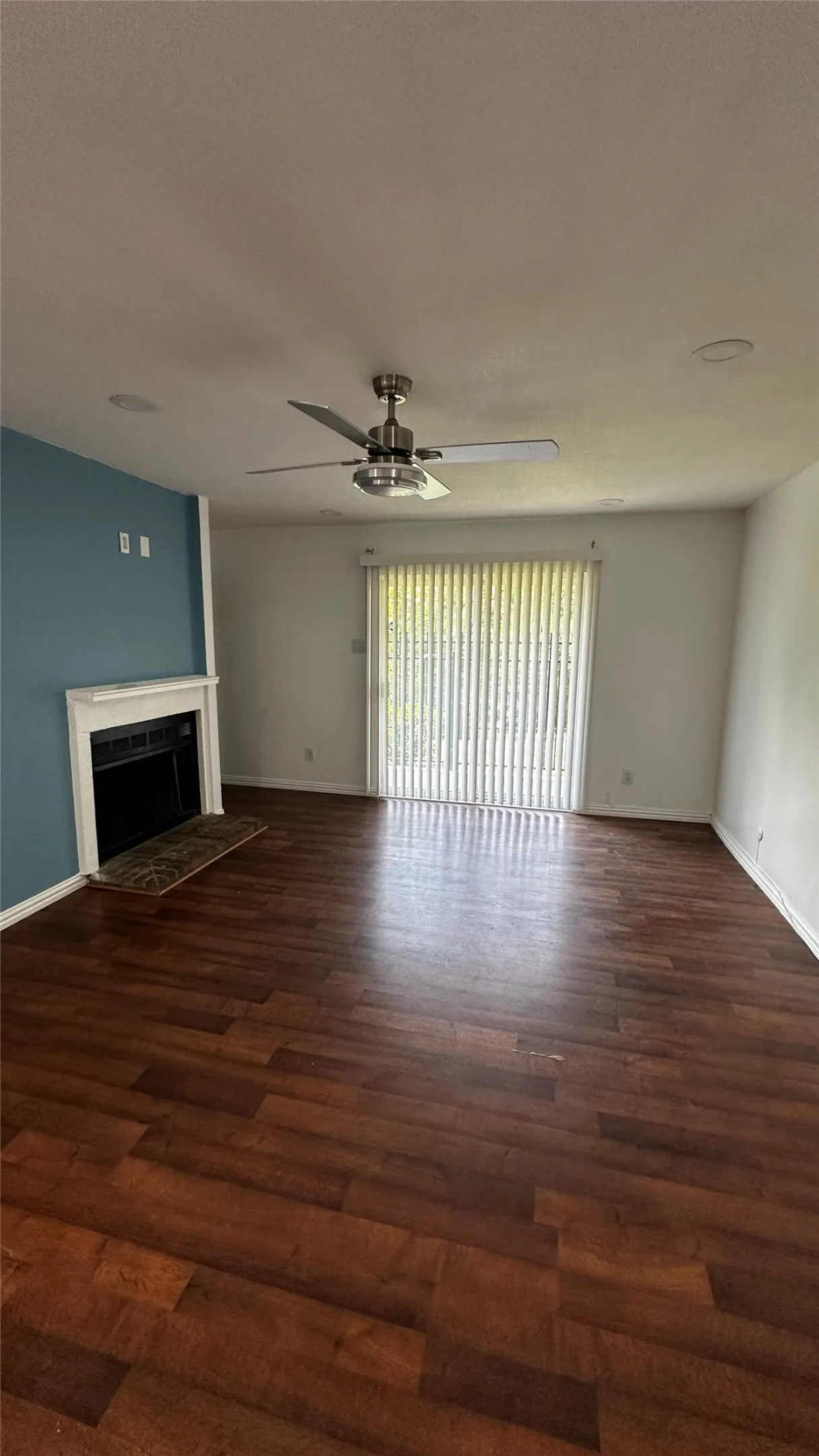 Spacious room featuring wood-finish flooring, a contemporary ceiling fan, and recessed lighting