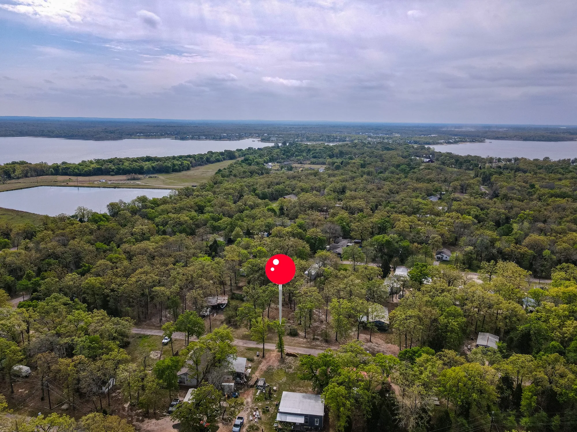 Drone / aerial view of a nearby body of water and a forest