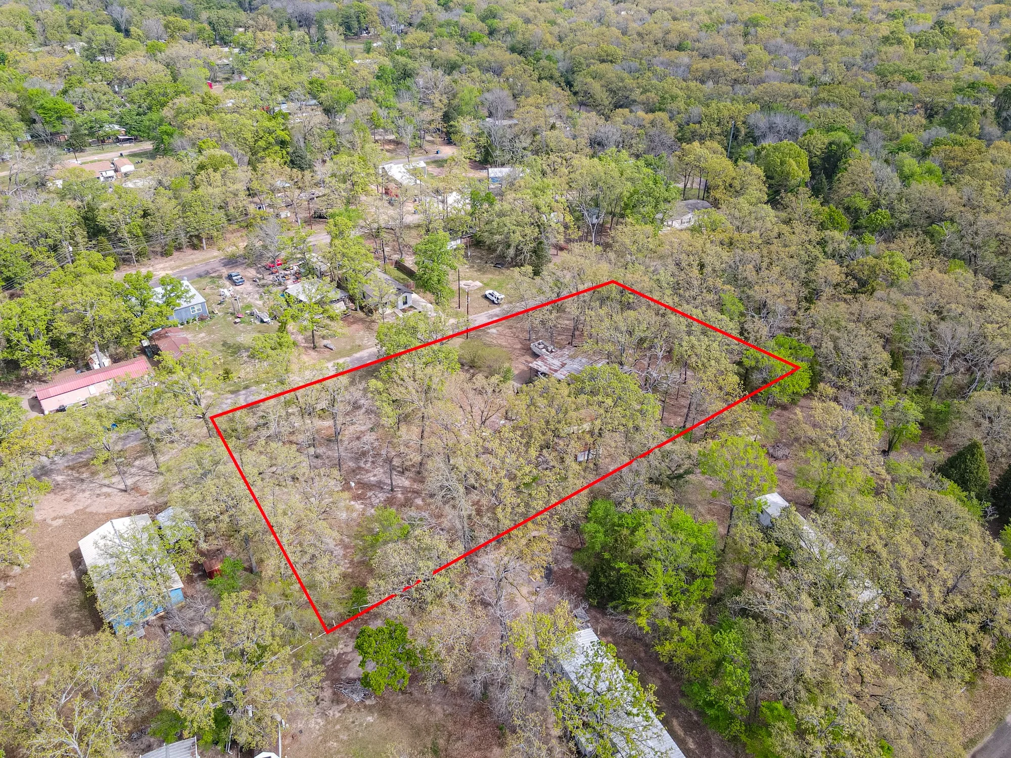 Aerial overview of property's location featuring property boundaries highlighted and a forest