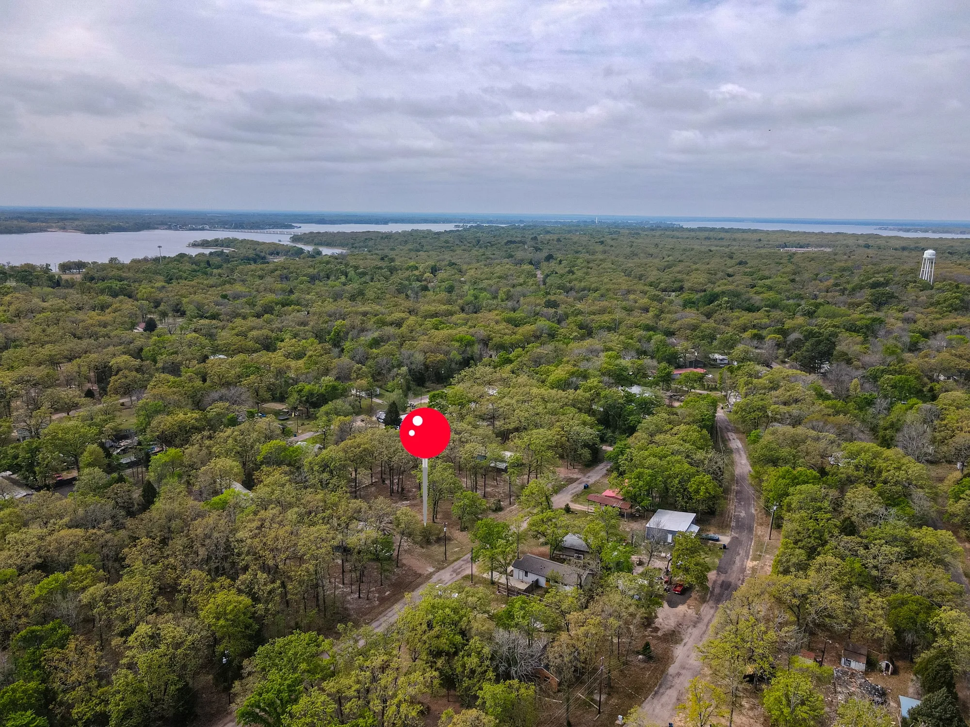 Drone / aerial view of a large body of water and a heavily wooded area