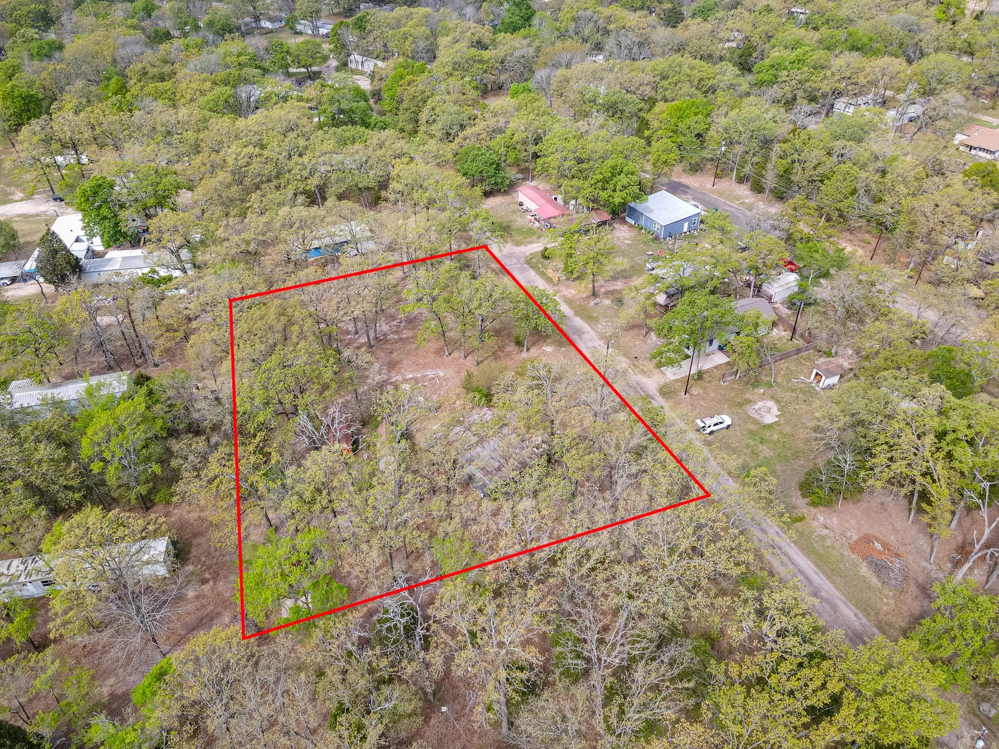 Aerial view of property and surrounding area with property boundaries highlighted and a forest