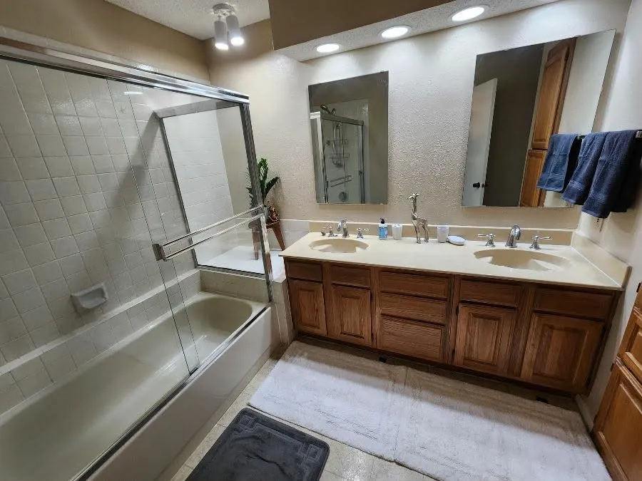 Primary Bathroom featuring double vanity and a textured wall