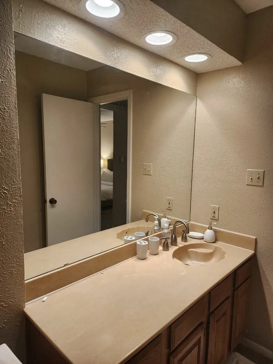Half Bathroom featuring a textured wall, vanity, and recessed lighting