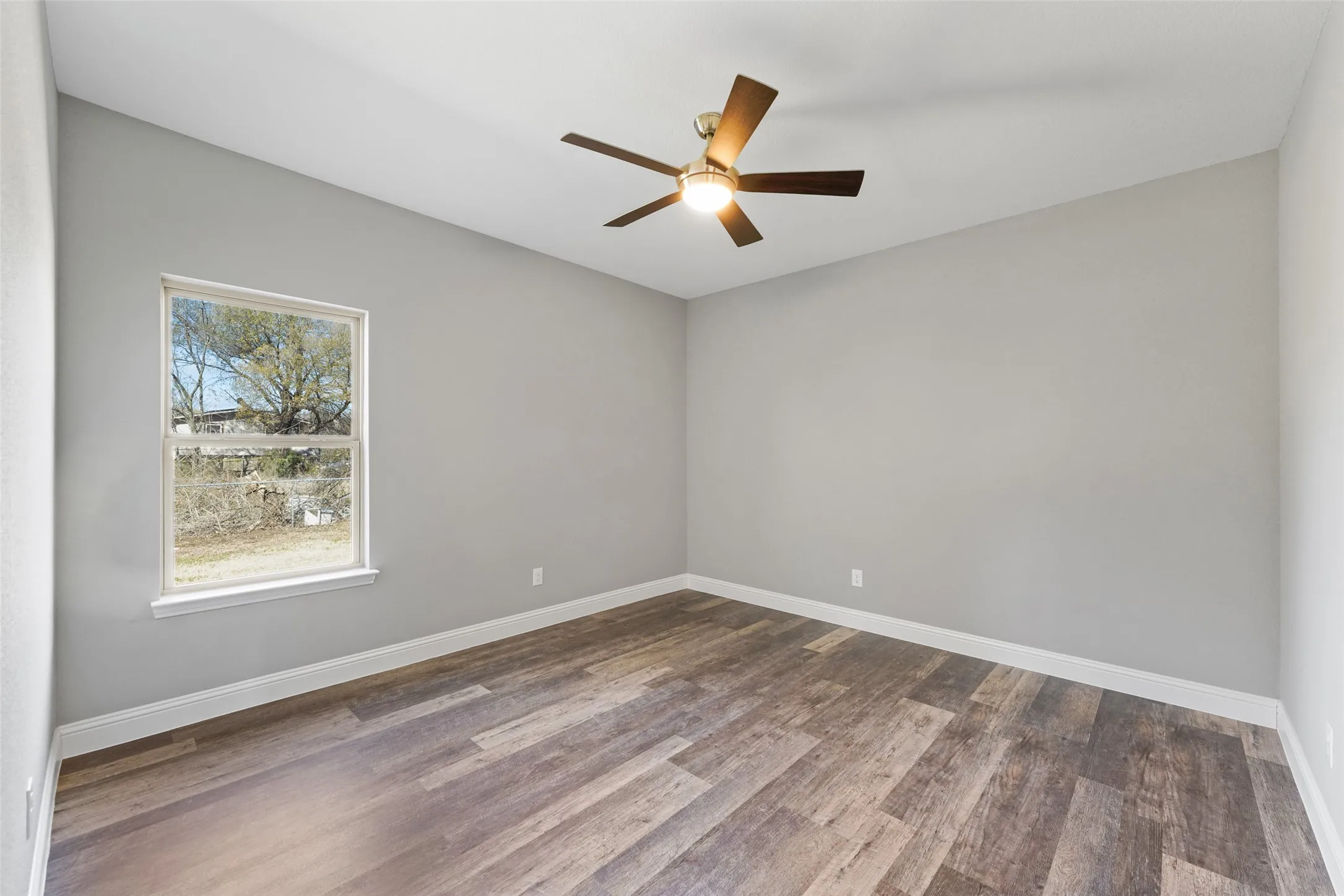 Unfurnished room featuring a ceiling fan and wood finished floors
