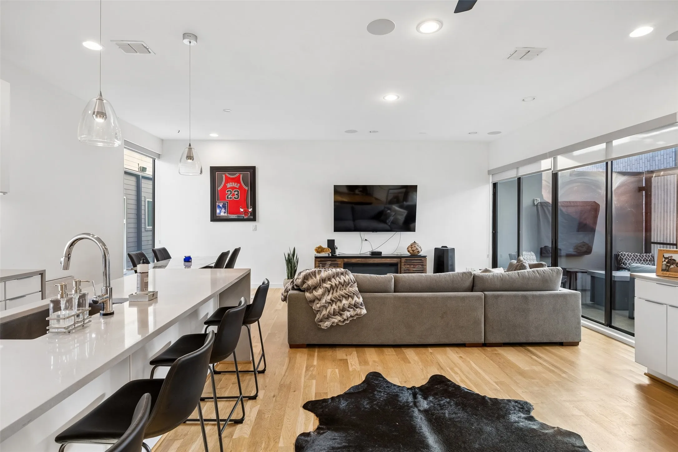 Open concept living area with hardwood floors, recessed lighting, and large glass doors