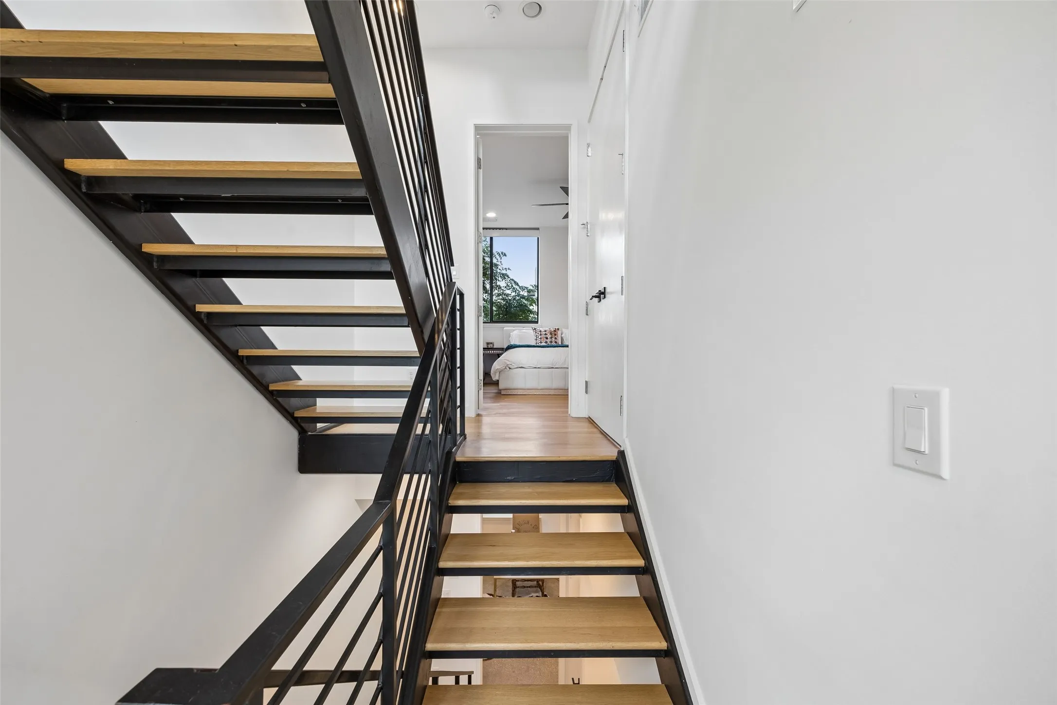 Modern staircase with light wood treads and dark metal railings