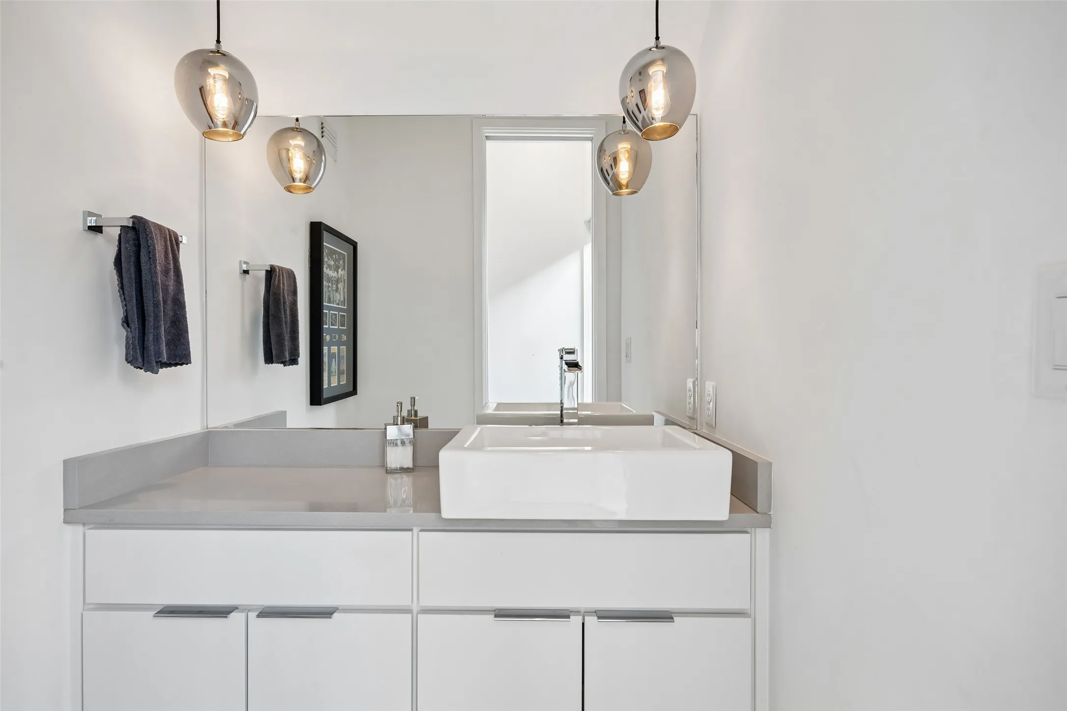 This bathroom features a contemporary floating vanity with a vessel sink and a large mirror