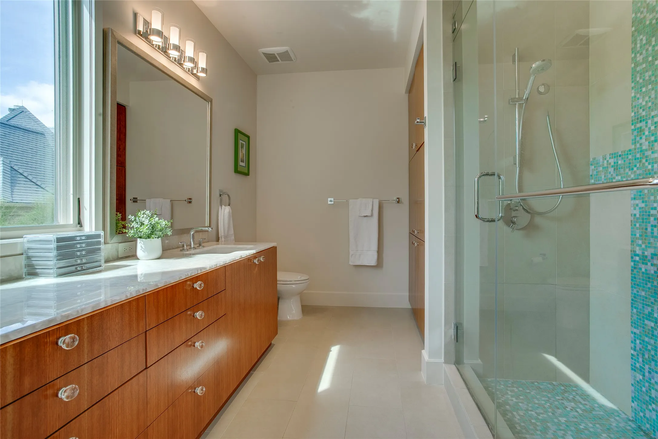 En suite guest bathroom for upstairs bedroom.  Walk in shower and oversized vanity with marble countertops.