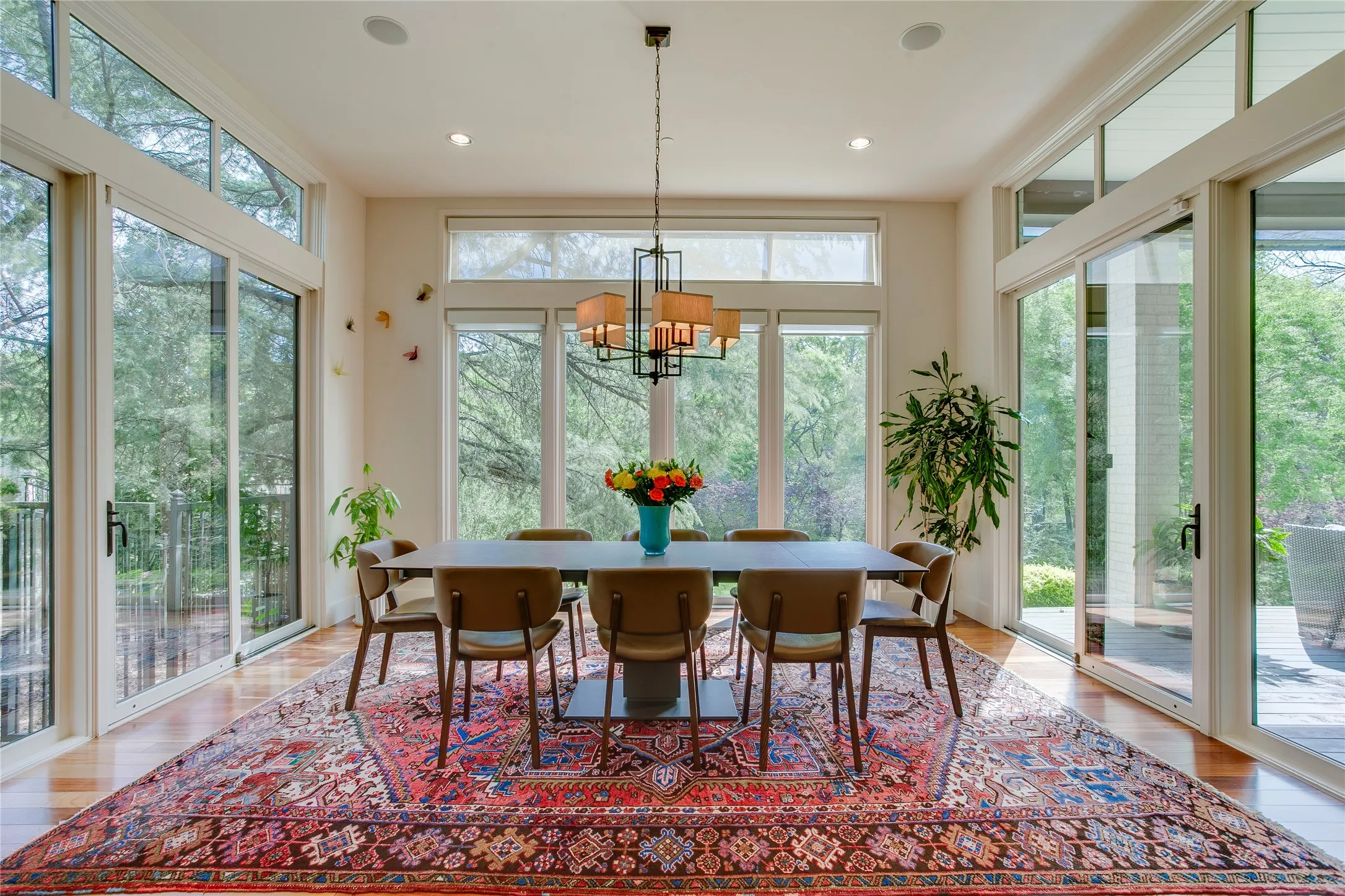 Walls of windows burng the outdoors in for the breakfast nook open to the kitchen and living room.