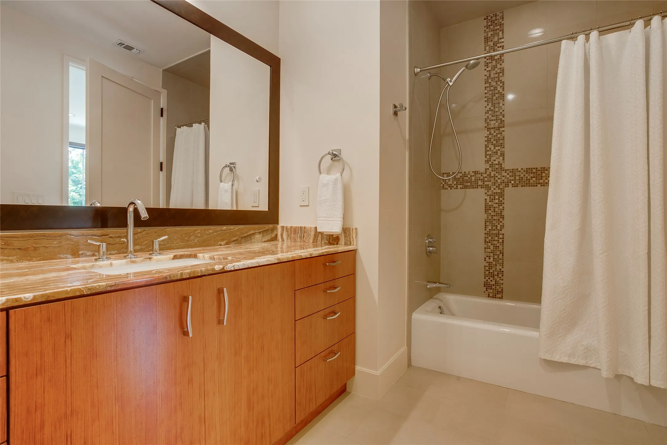 En suite bathroom with shower and tub combination with oversized vanity.
