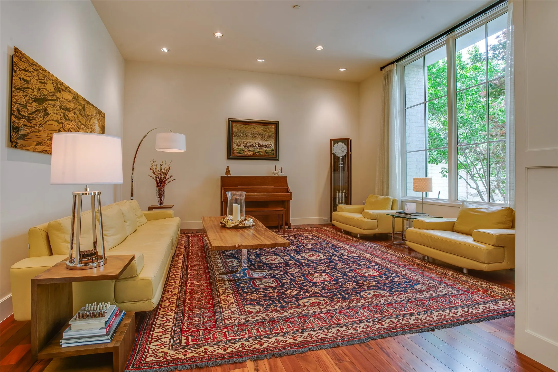 Spacious formal living room with grand windows overlooking the lush front yard.