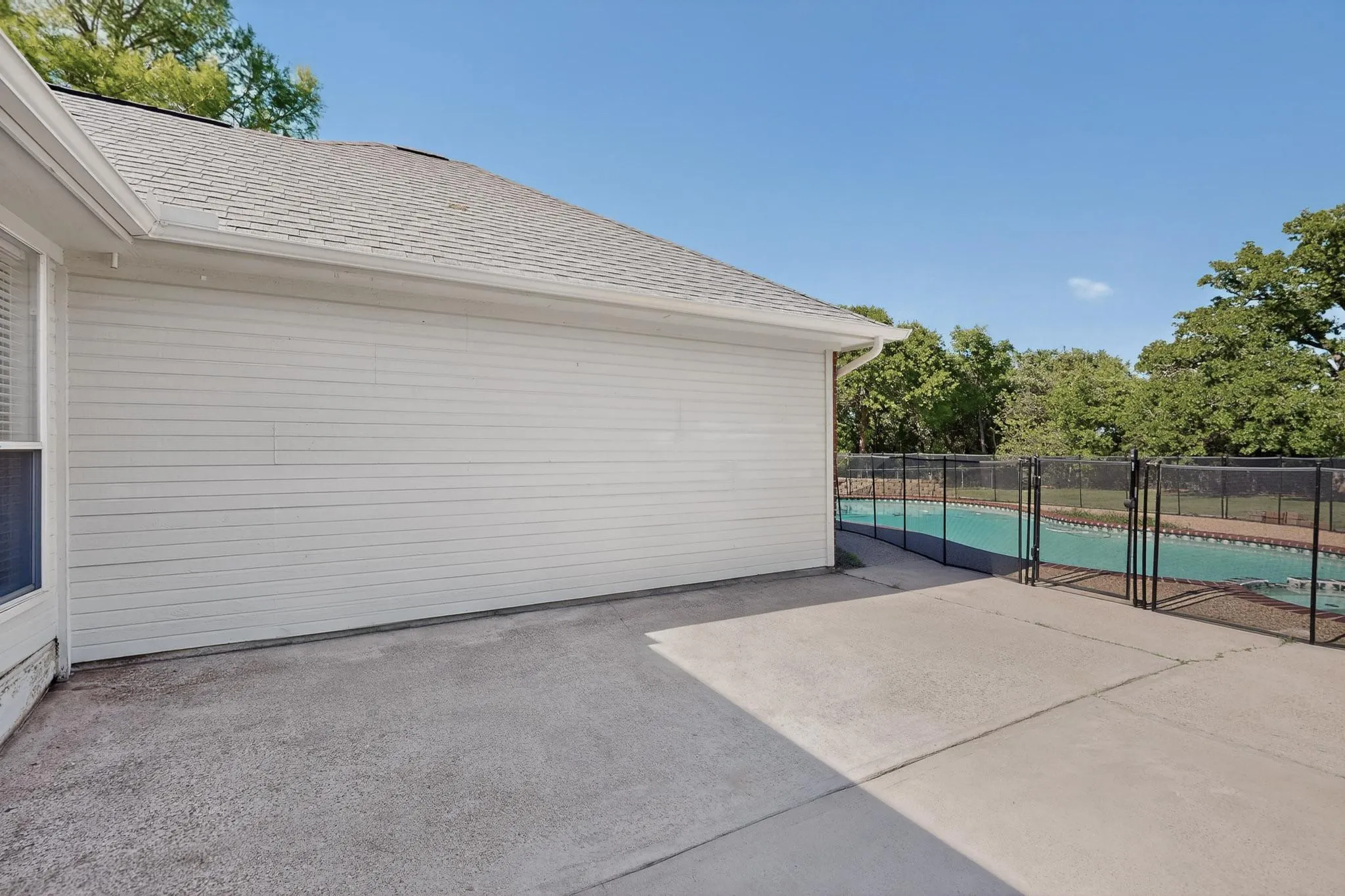 Patio with access to garage and overlooks pool.