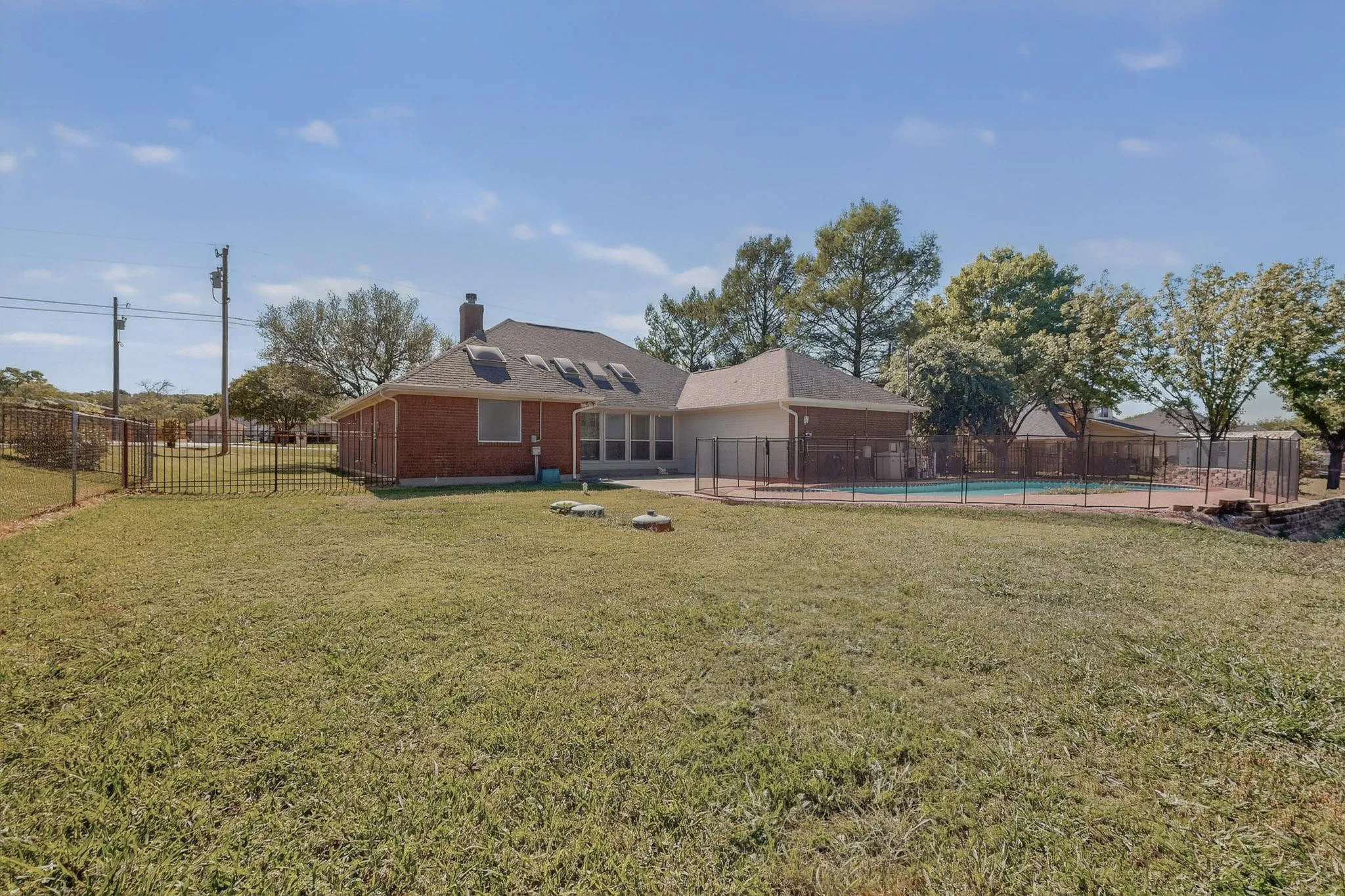 Back of house with a chimney, a patio area, and brick siding