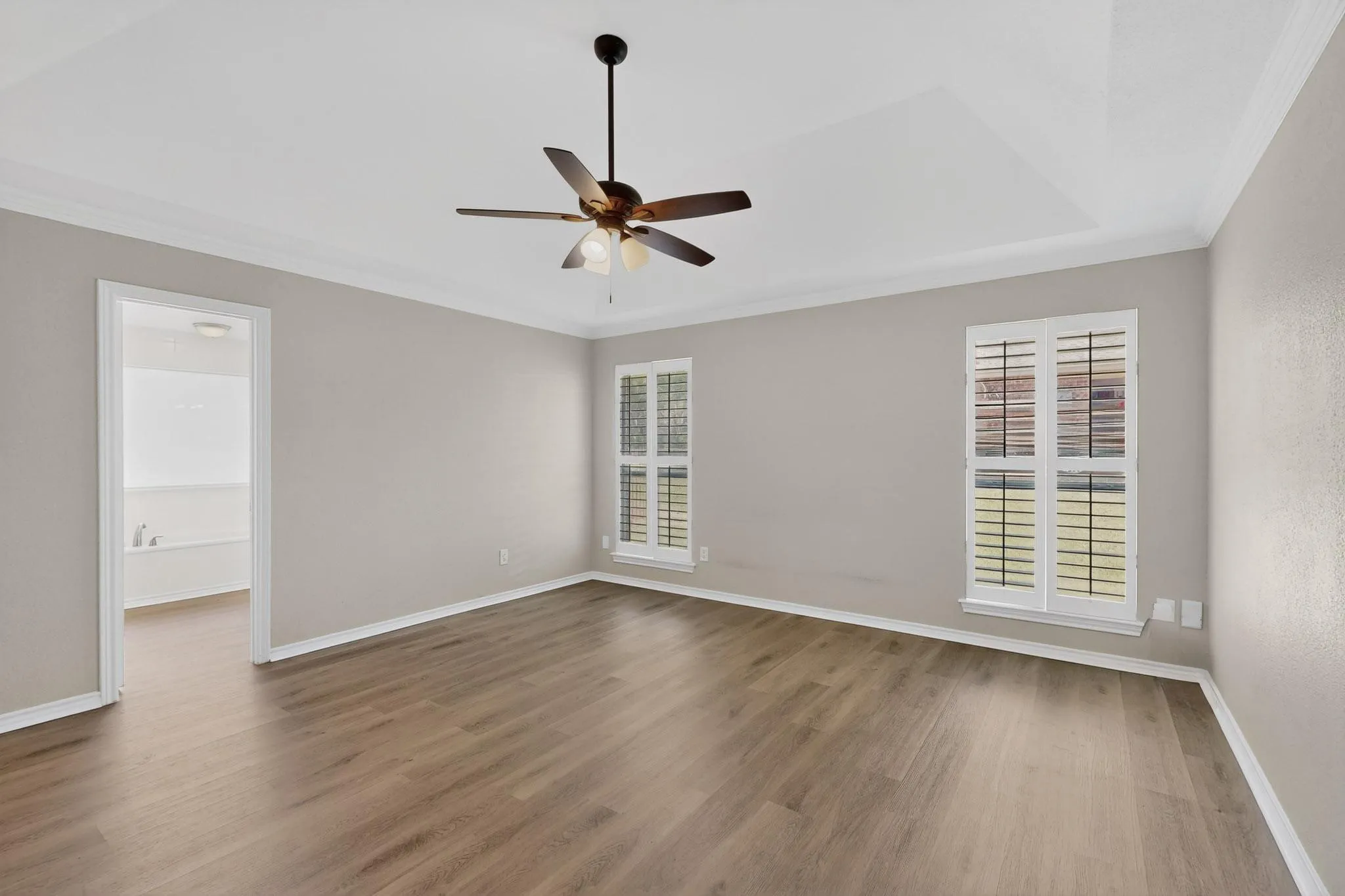 Spare room with ornamental molding, ceiling fan, and dark wood-style floors
