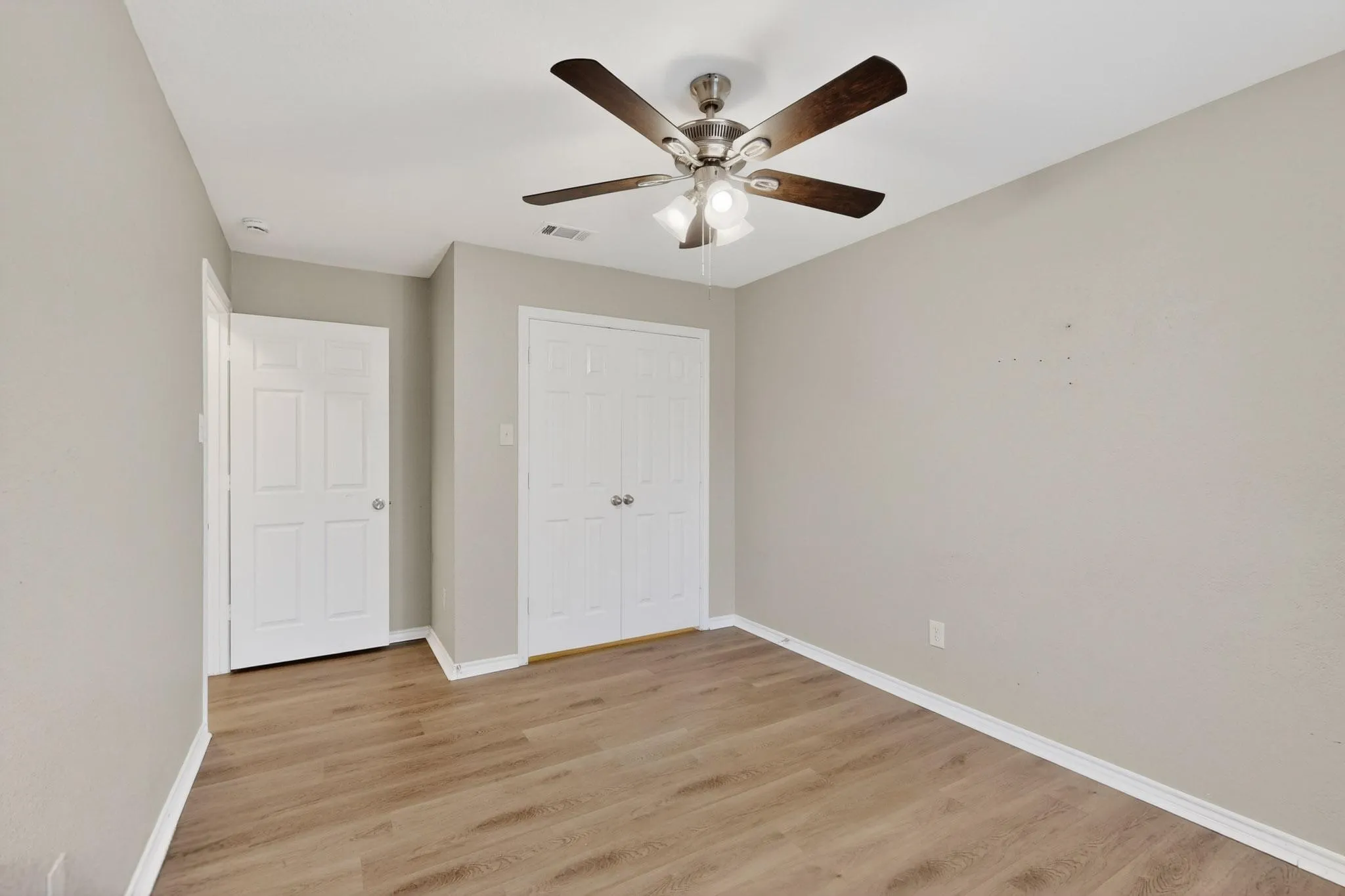 Unfurnished bedroom with light wood-style flooring, a closet, and ceiling fan