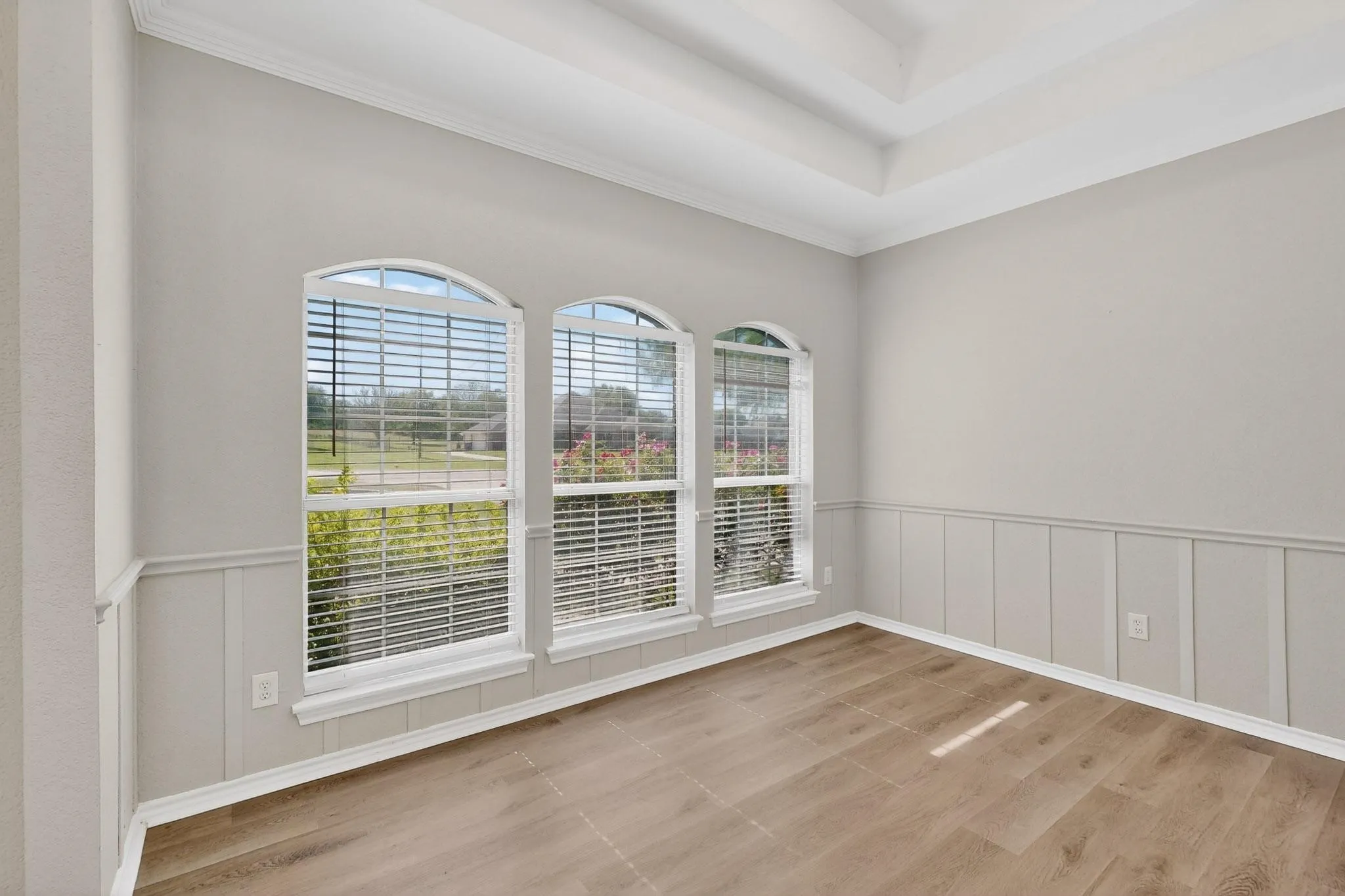 Unfurnished room featuring wainscoting, a decorative wall, and ornamental molding