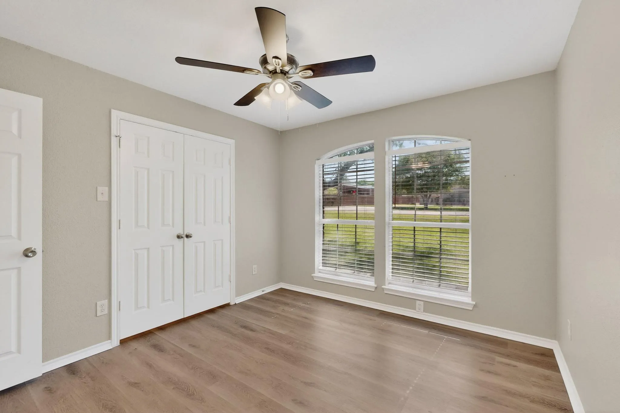 Unfurnished bedroom featuring light wood-type flooring, a ceiling fan, and a closet