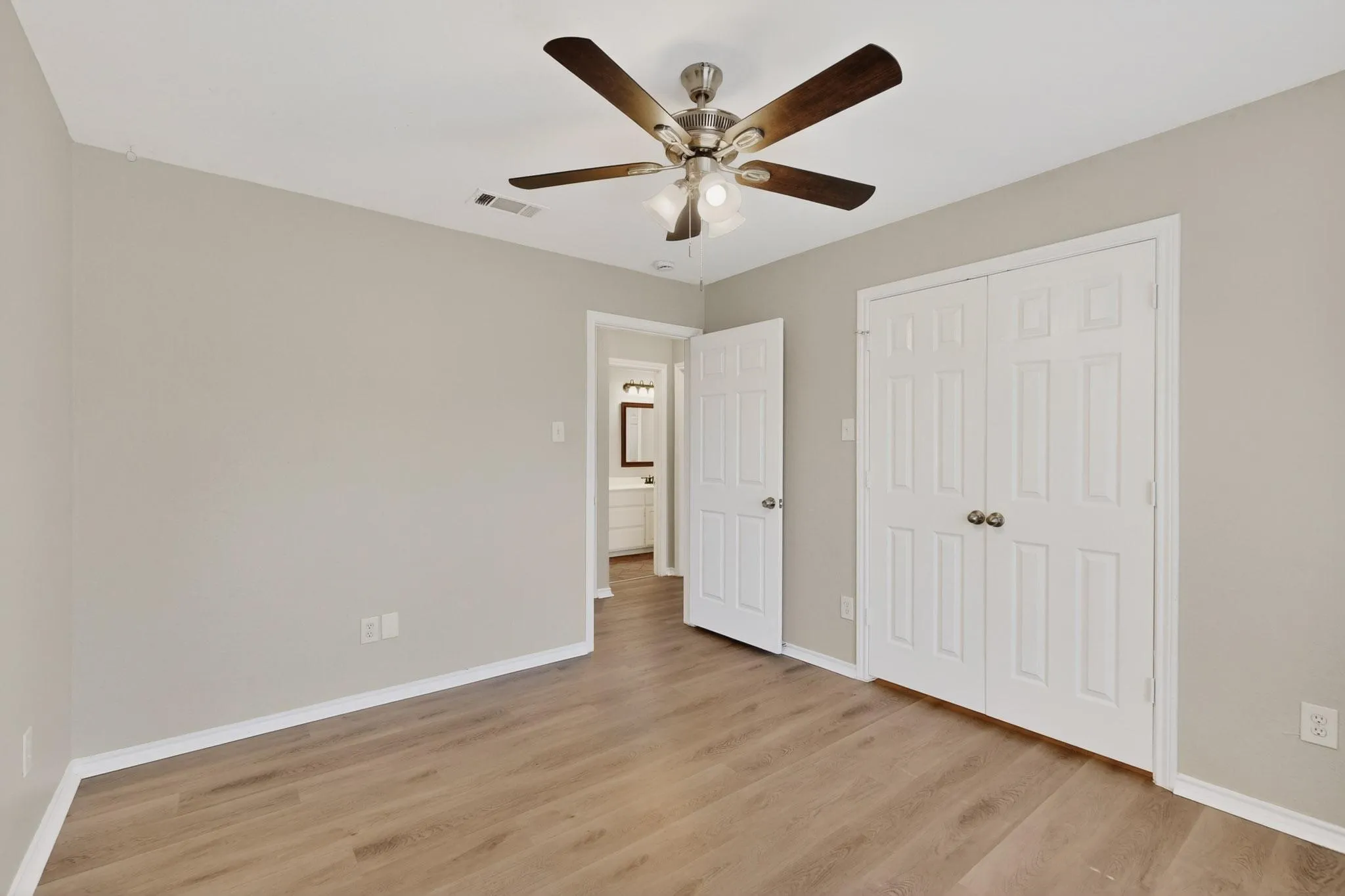 Unfurnished bedroom with light wood finished floors, a closet, and ceiling fan