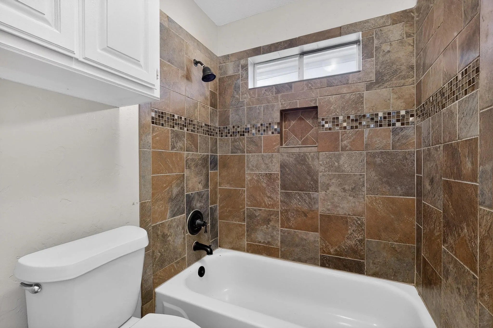 Full bath featuring toilet and tub / shower combination