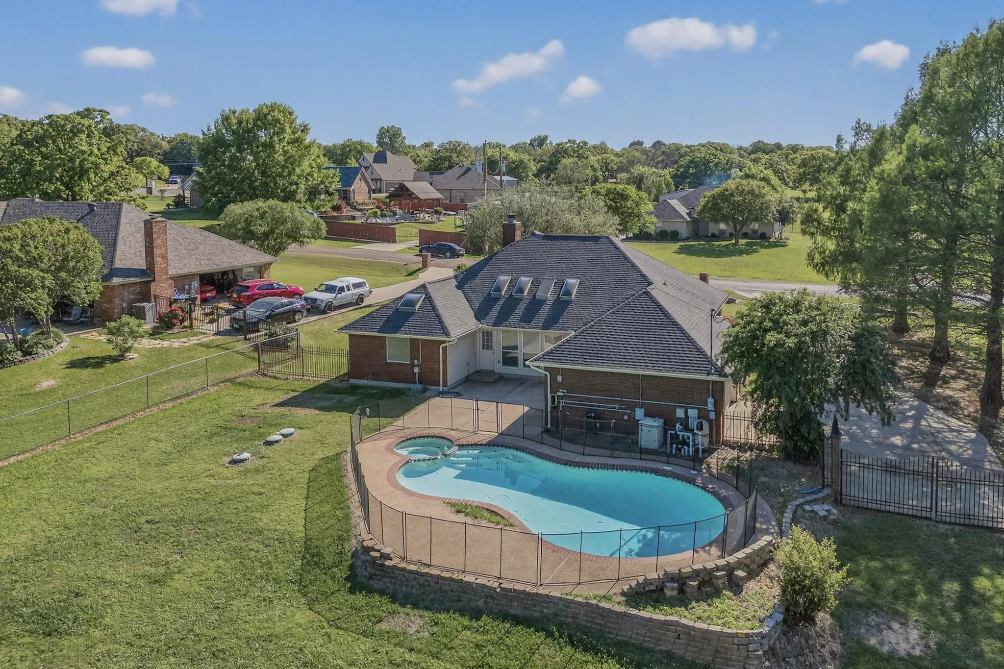 Relaxing pool / spa featuring a patio area, a fenced backyard, and view of wooded area