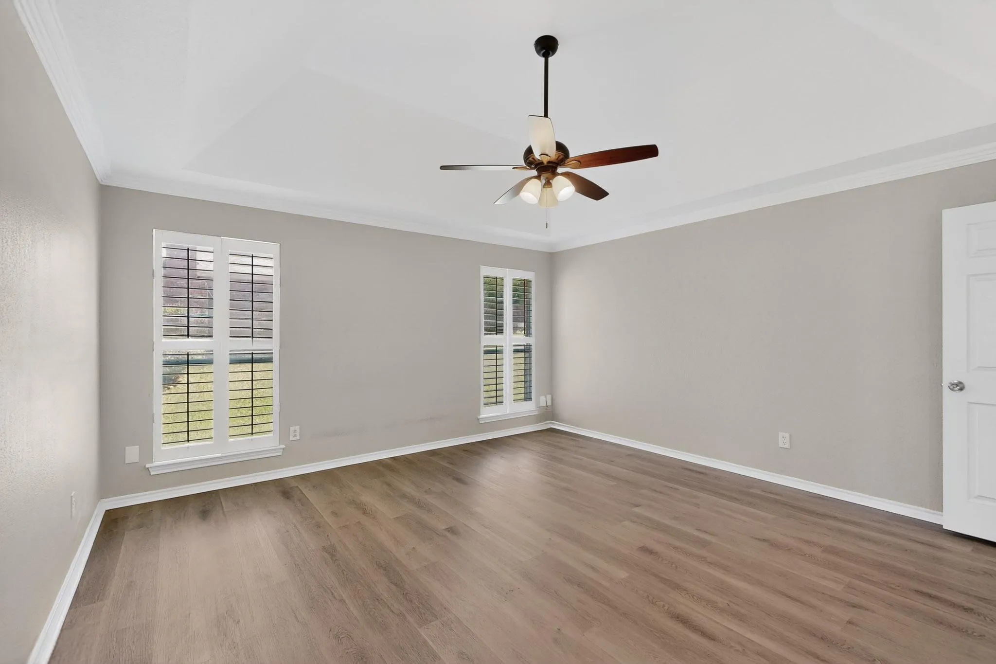 Unfurnished room with crown molding, dark wood-style floors, and a ceiling fan