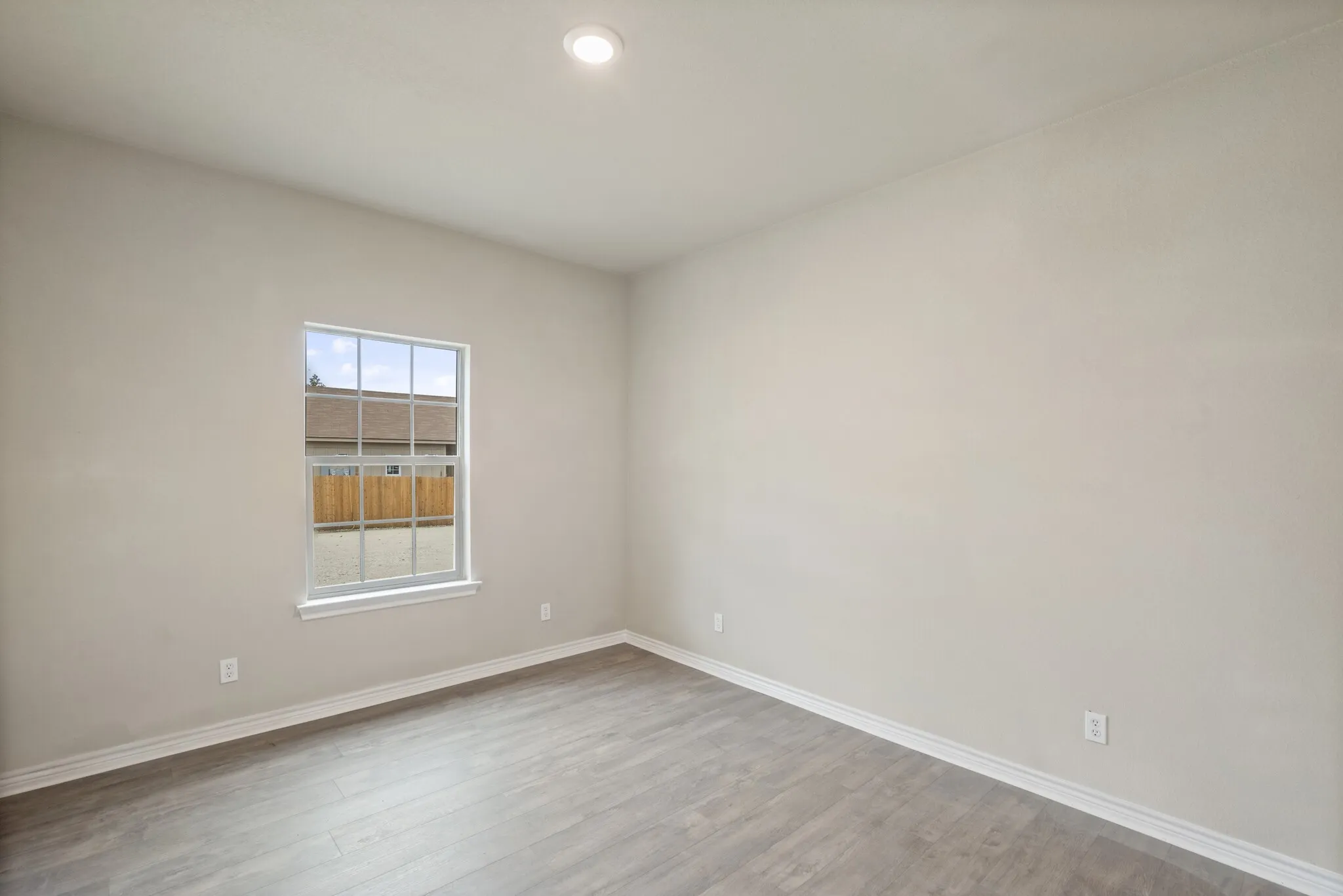 Empty room featuring light wood-style flooring and recessed lighting
