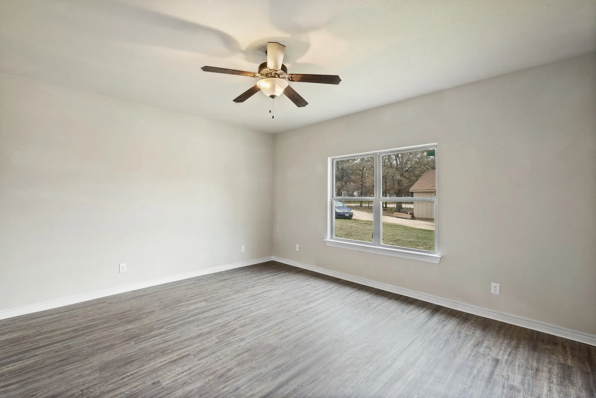 Unfurnished room with dark wood-style flooring and a ceiling fan